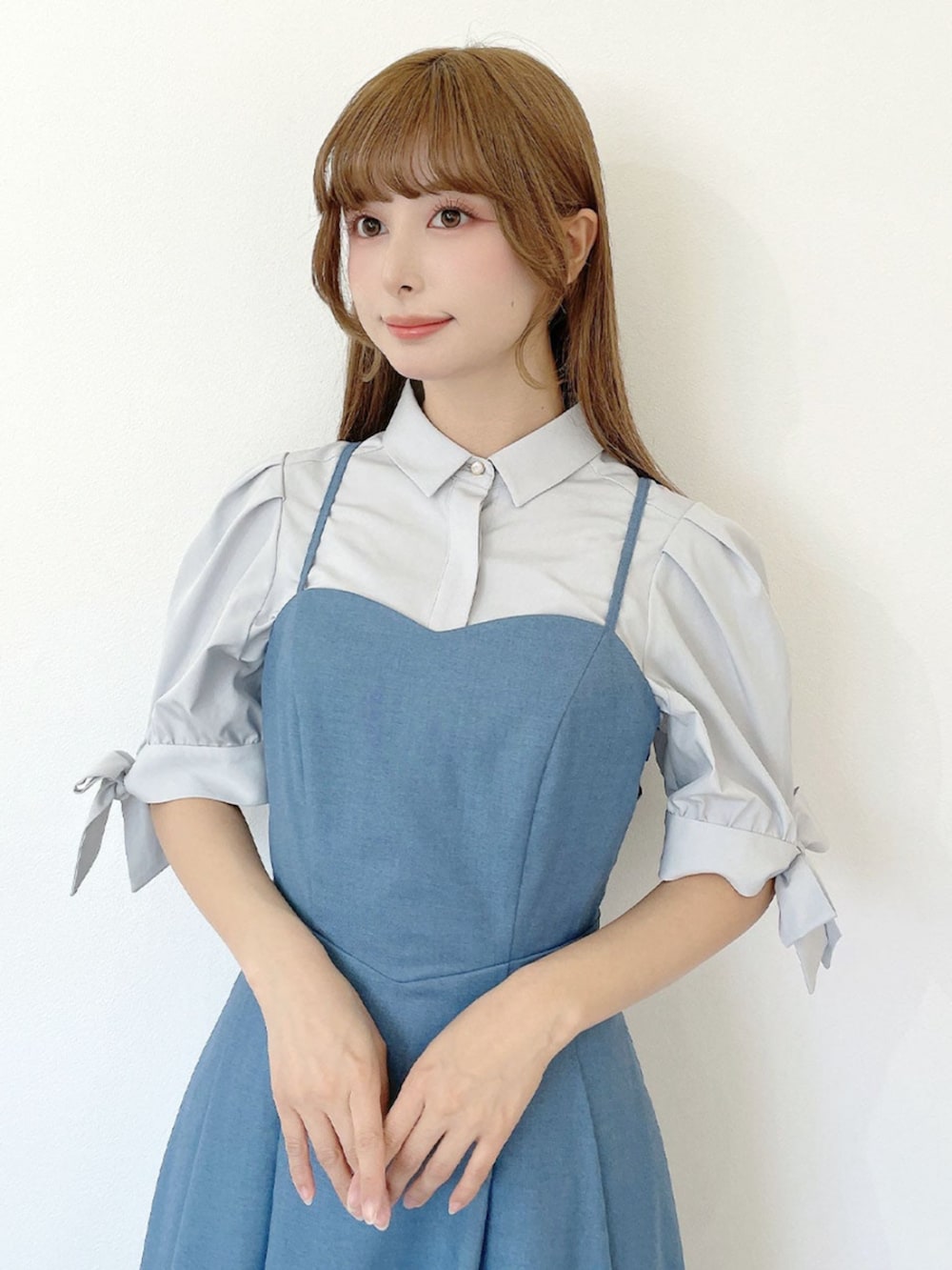 ホワイト系のサンダル、ホワイト系のハンドバッグ、ブルー系のワンピースを着用したレディースの夏コーディネートの4枚目の写真