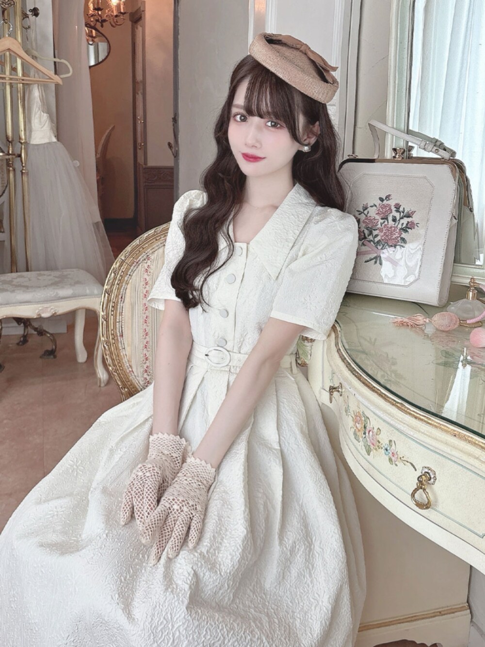 レッド系のカーディガン/ボレロ、ホワイト系のワンピースを着用したレディースの春コーディネートの2枚目の写真