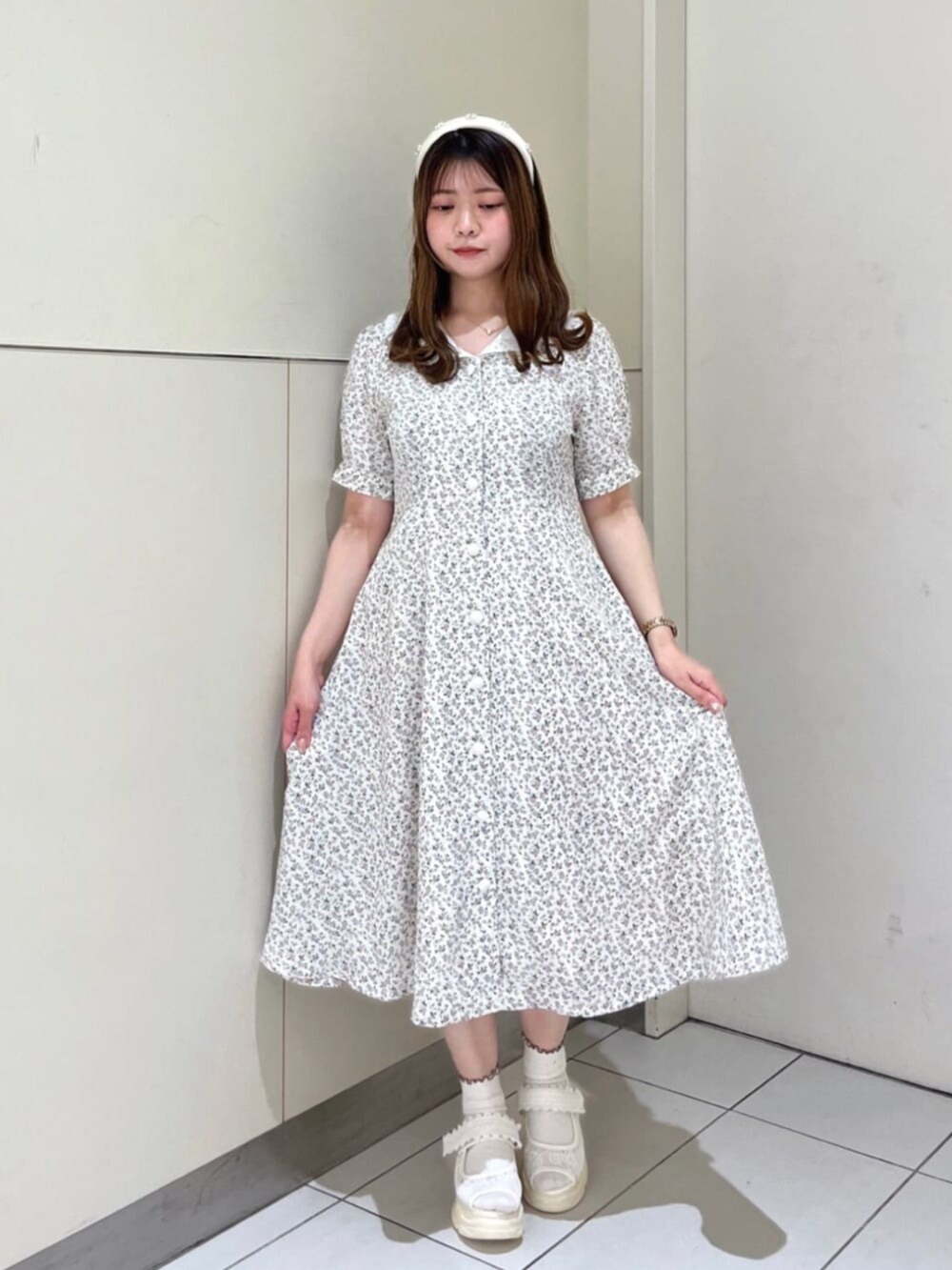 ホワイト系のハンドバッグ、ホワイト系のサンダル、ピンク系のカーディガン/ボレロを着用したレディースの夏コーディネートの3枚目の写真