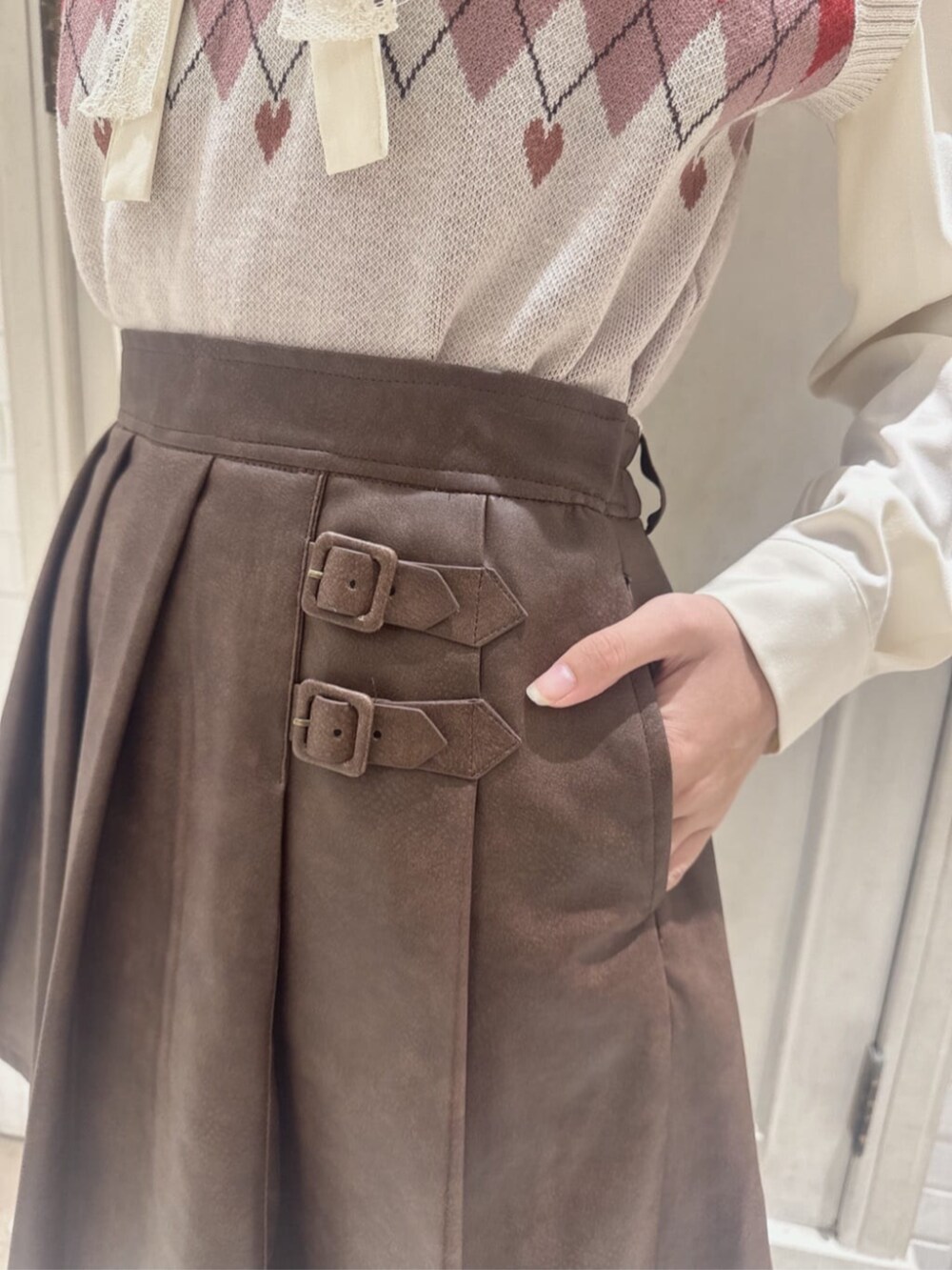 ブラウン系のスカート、ブラウン系のパンプス、ベージュ系のボストンバッグを着用したレディースの秋コーディネートの2枚目の写真