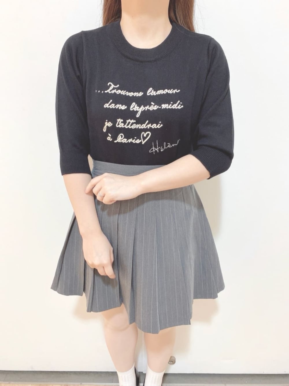 グレー系のスカート、ブラック系のハンドバッグ、ブラック系のローファーを着用したレディースの秋コーディネートの5枚目の写真