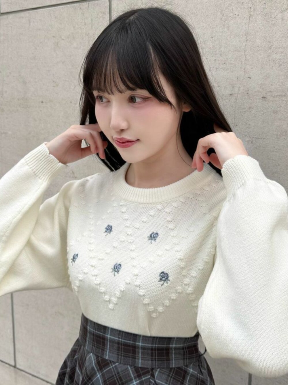ブラック系のローファー、ブルー系のスカート、ホワイト系のニット/セーターを着用したレディースの冬コーディネートの2枚目の写真