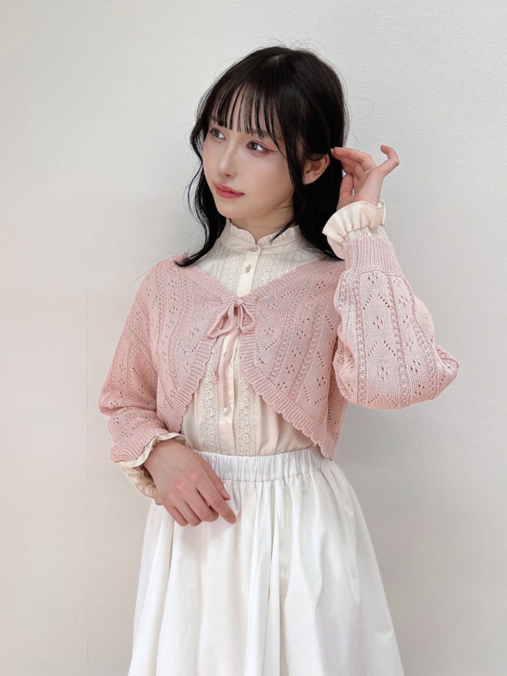 ホワイト系のスニーカー、ベージュ系のシャツ/ブラウス、ホワイト系のスカートを着用したレディースの春コーディネートの2枚目の写真