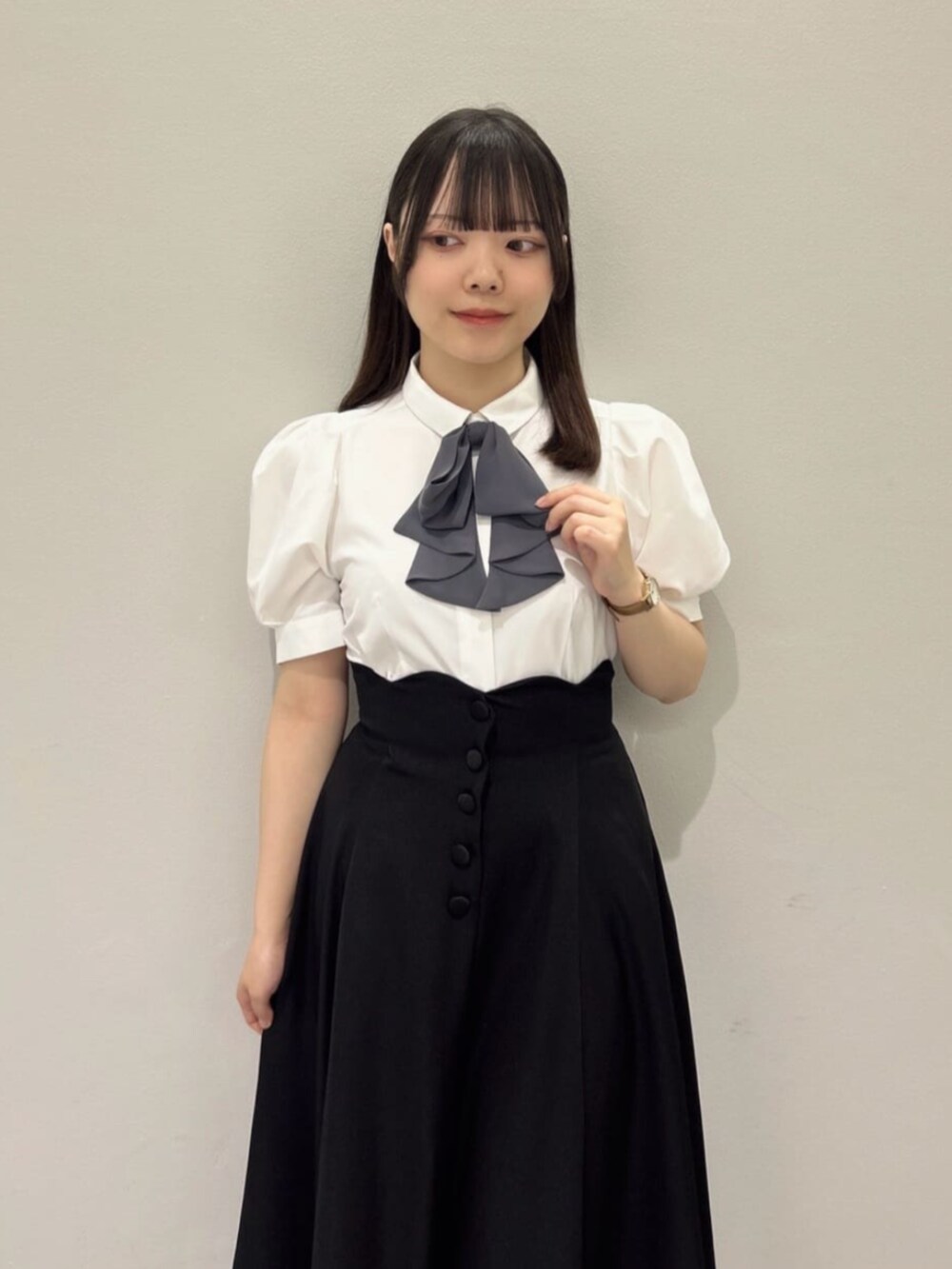 ブラック系のスカート、ホワイト系のシャツ/ブラウス、ブラック系のパンプスを着用したレディースの春コーディネートの3枚目の写真