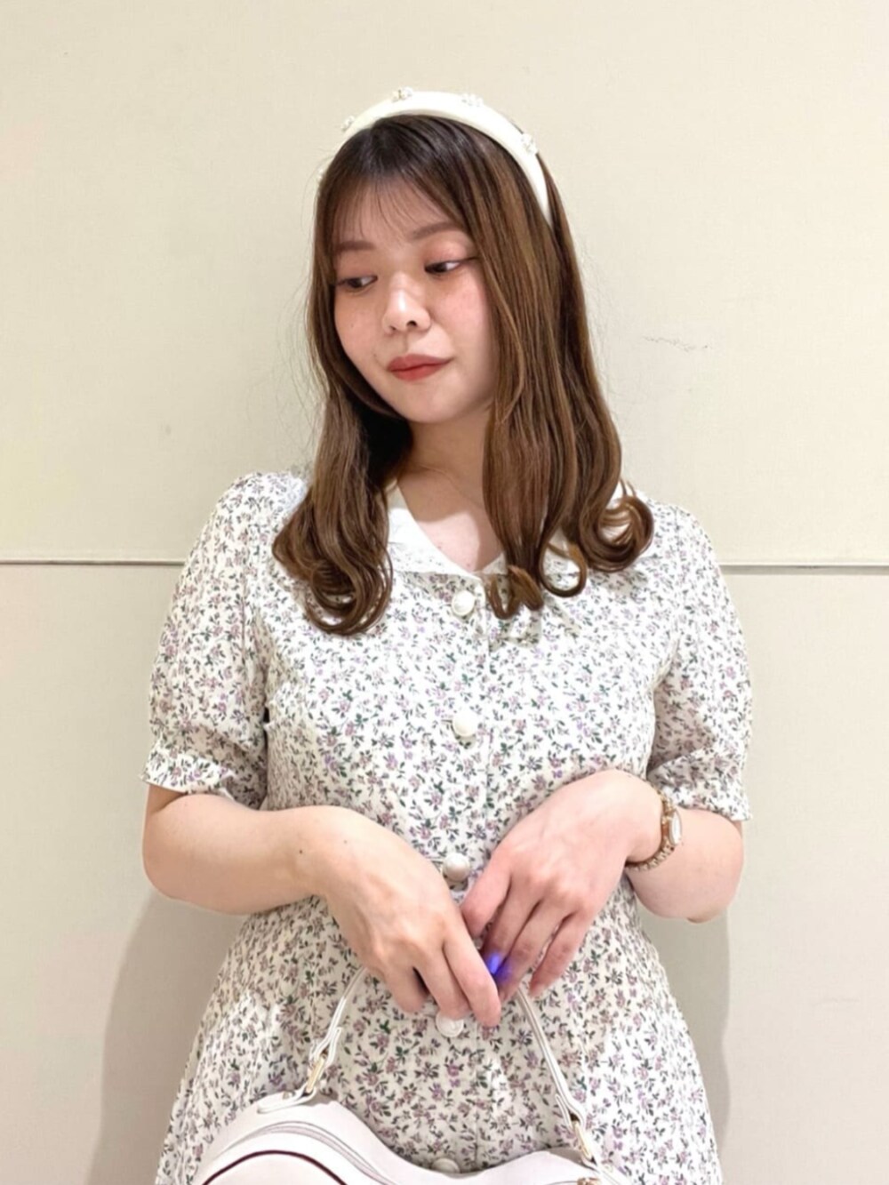 ホワイト系のハンドバッグ、ホワイト系のサンダル、ピンク系のカーディガン/ボレロを着用したレディースの夏コーディネートの4枚目の写真