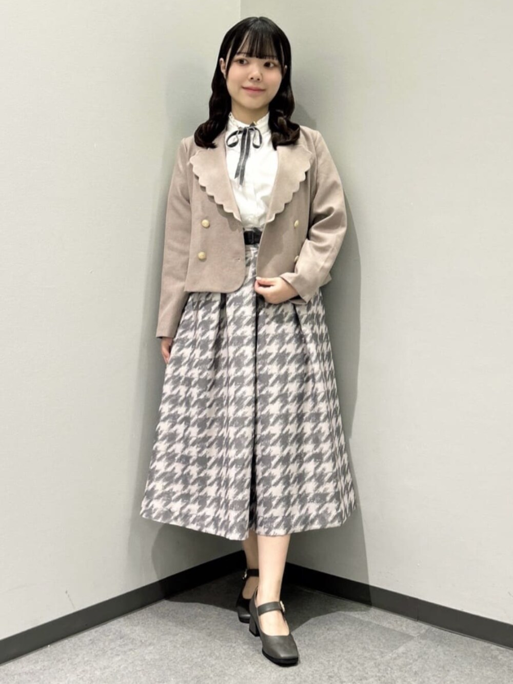 グレー系のスカート、ピンク系のセットアップ、ホワイト系のシャツ/ブラウスを着用したレディースの秋コーディネートの2枚目の写真