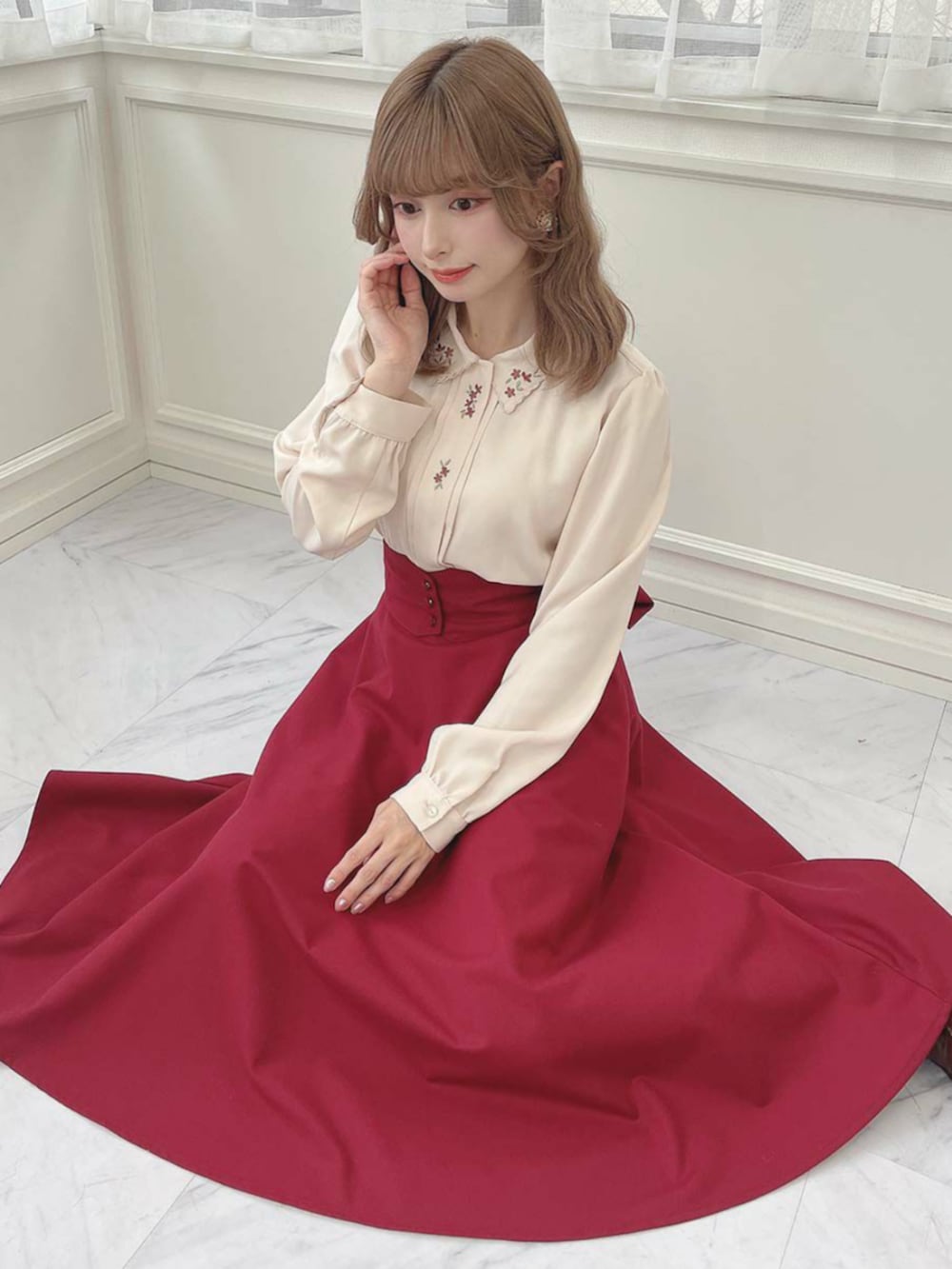 ブラウン系のローファー、レッド系のスカート、ベージュ系のシャツ/ブラウスを着用したレディースの秋コーディネートの2枚目の写真