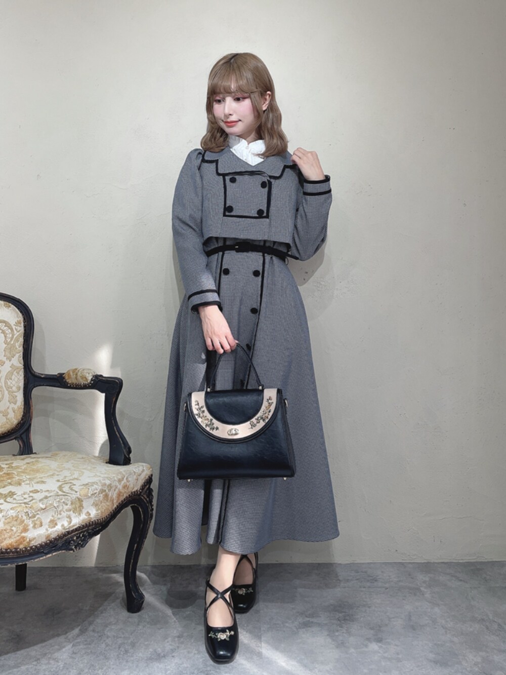 ホワイト系のシャツ/ブラウス、ブラック系のセットアップ、ブラック系のハンドバッグを着用したレディースの秋コーディネートの2枚目の写真