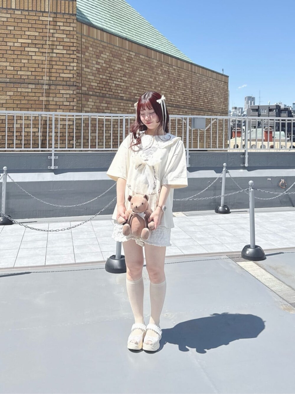 ホワイト系のサンダル、ホワイト系のセットアップ、ホワイト系のTシャツ/カットソーを着用したレディースの春コーディネートの2枚目の写真