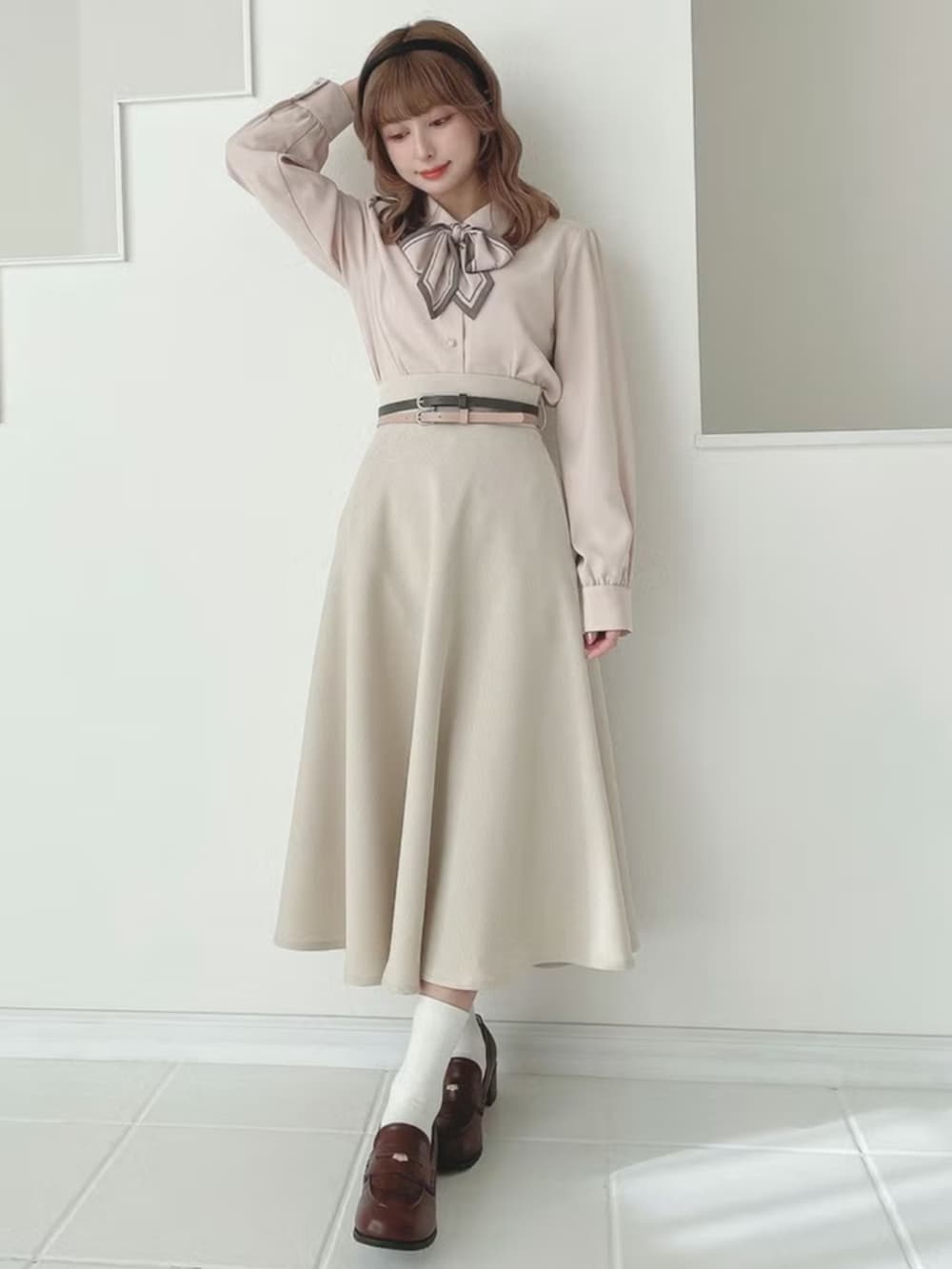 ブラウン系のローファー、ベージュ系のスカート、ピンク系のシャツ/ブラウスを着用したレディースの春コーディネートの2枚目の写真