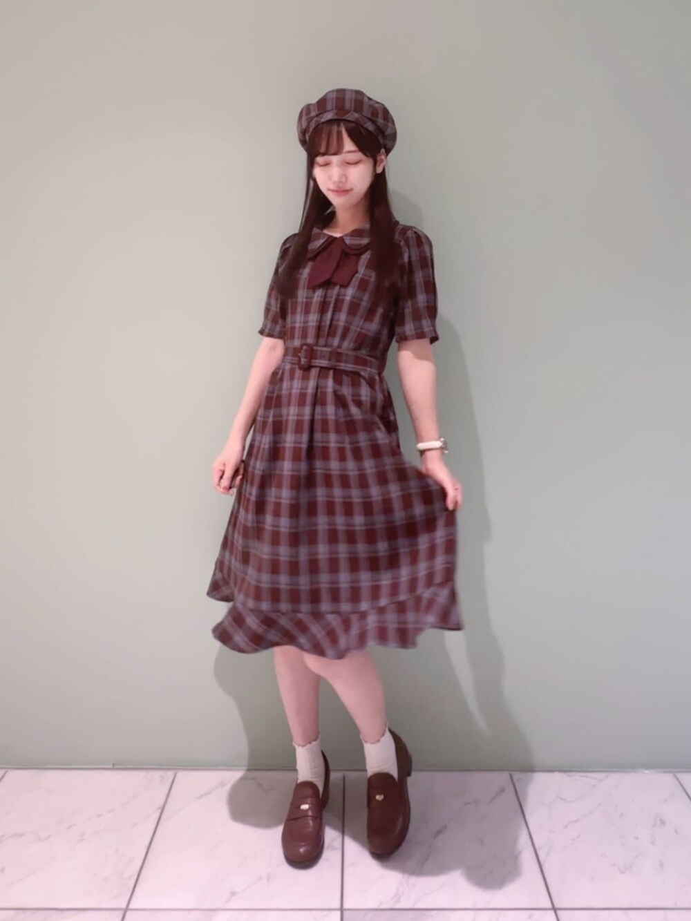 ブラウン系のローファー、レッド系のワンピース、レッド系のハンチング/ベレー帽を着用したレディースの秋コーディネートの2枚目の写真