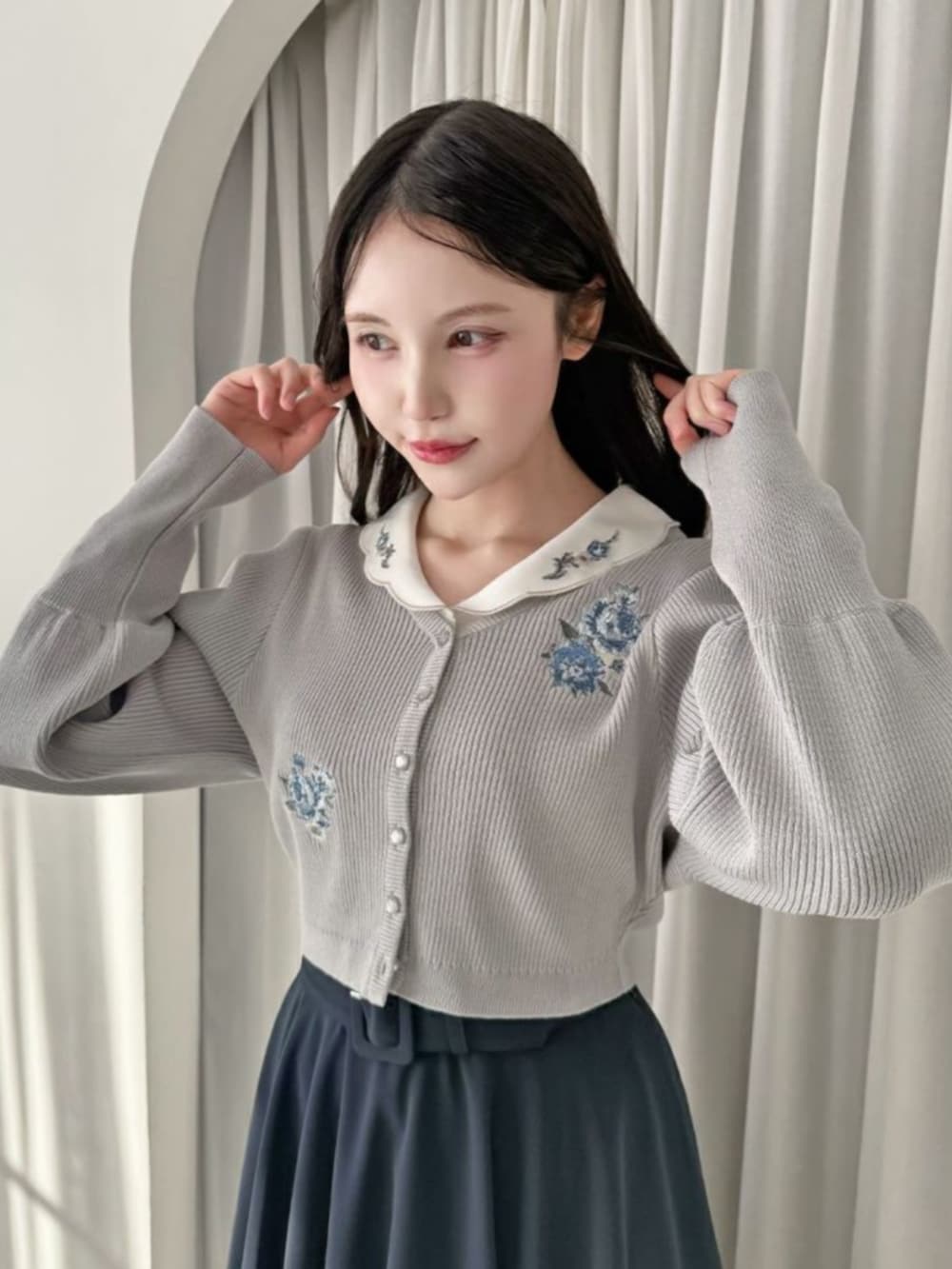 ブラック系のローファー、ブルー系のスカート、ホワイト系のシャツ/ブラウスを着用したレディースの冬コーディネートの3枚目の写真