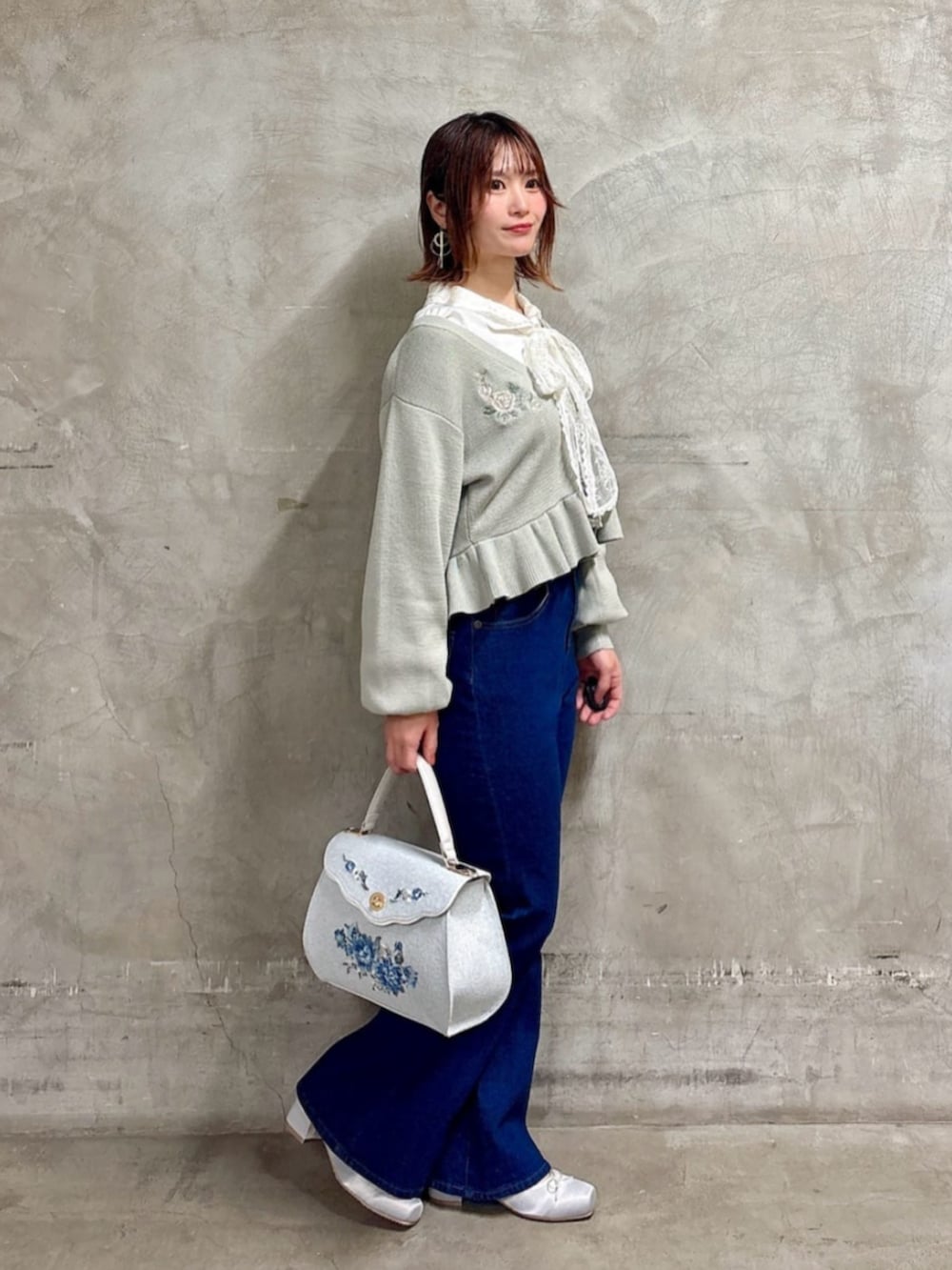 ブルー系のデニムパンツ、ホワイト系のシャツ/ブラウス、グレー系のパンプスを着用したレディースの冬コーディネートの2枚目の写真