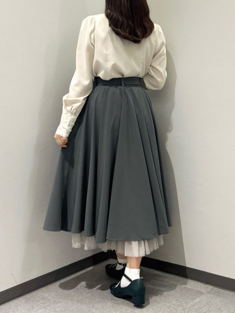 グリーン系のスカート、ピンク系のシャツ/ブラウス、ブルー系のハンドバッグを着用したレディースの秋コーディネートの3枚目の写真