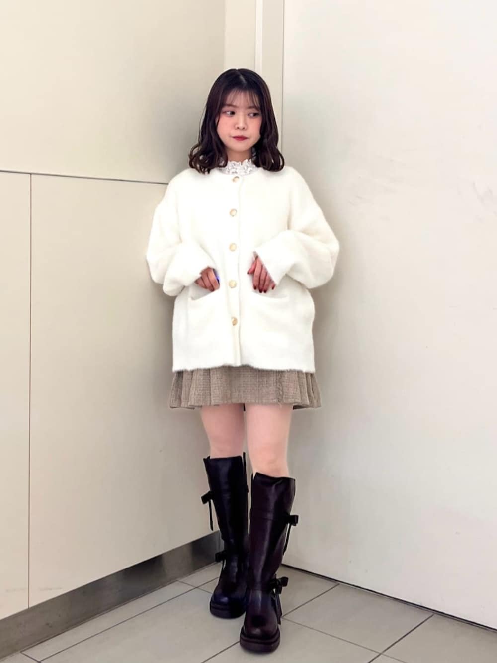 ホワイト系のTシャツ/カットソー、ブラウン系のブーツ、ホワイト系のカーディガン/ボレロを着用したレディースの秋コーディネートの2枚目の写真