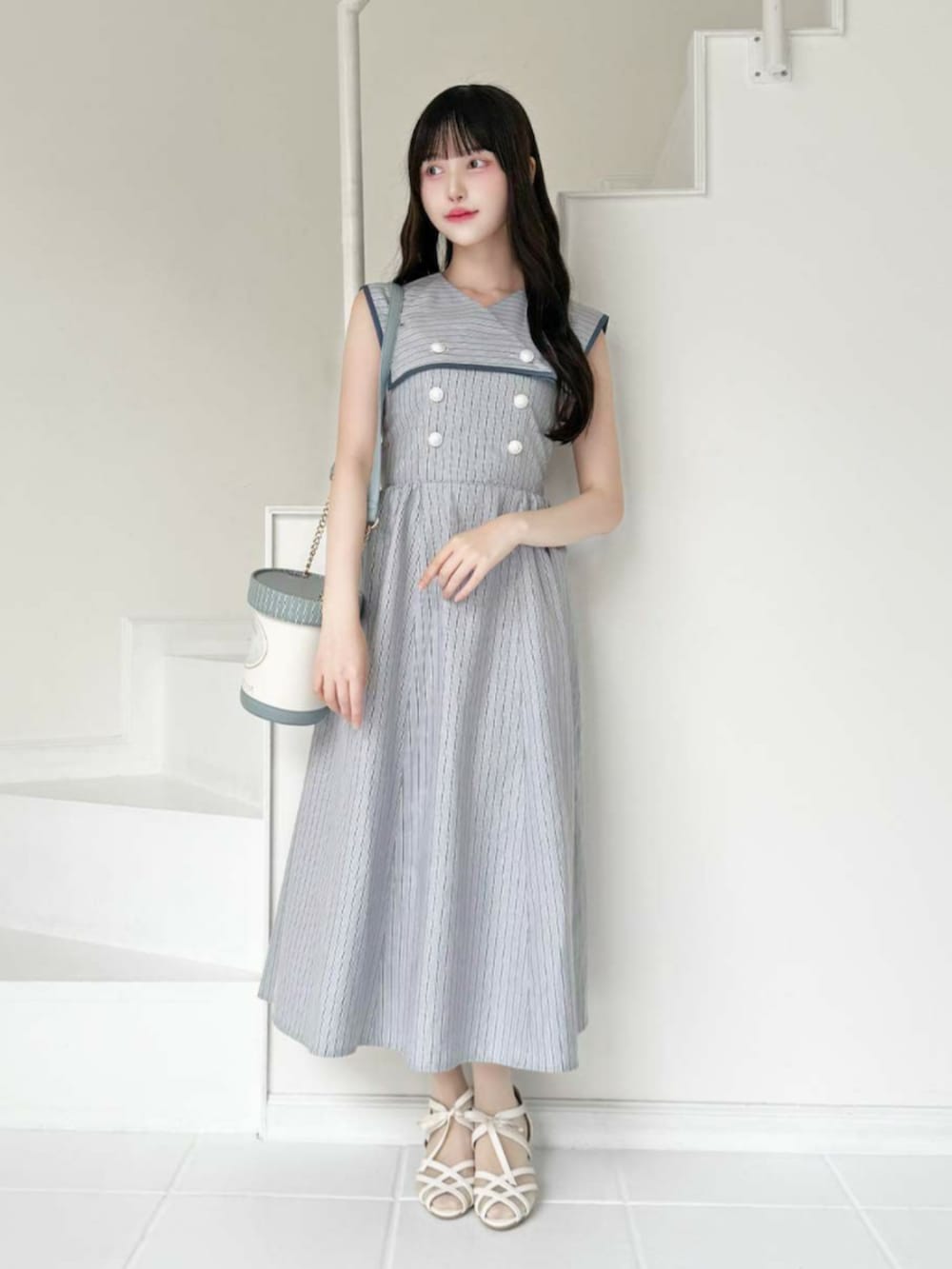 ブルー系のワンピースを着用したレディースの春コーディネートの2枚目の写真