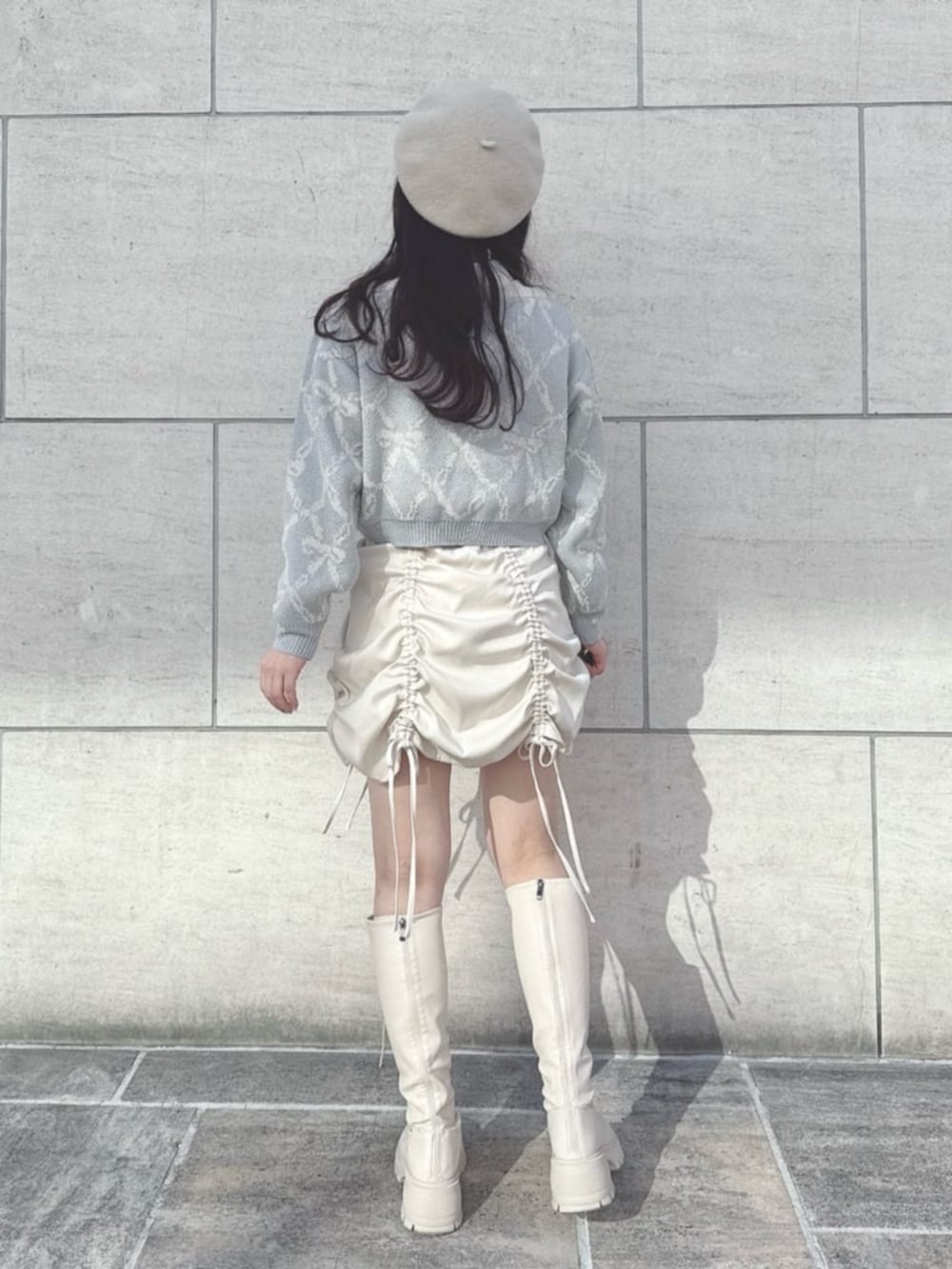 ホワイト系のニット/セーター、ホワイト系のシャツ/ブラウス、ホワイト系のスカートを着用したレディースの冬コーディネートの2枚目の写真