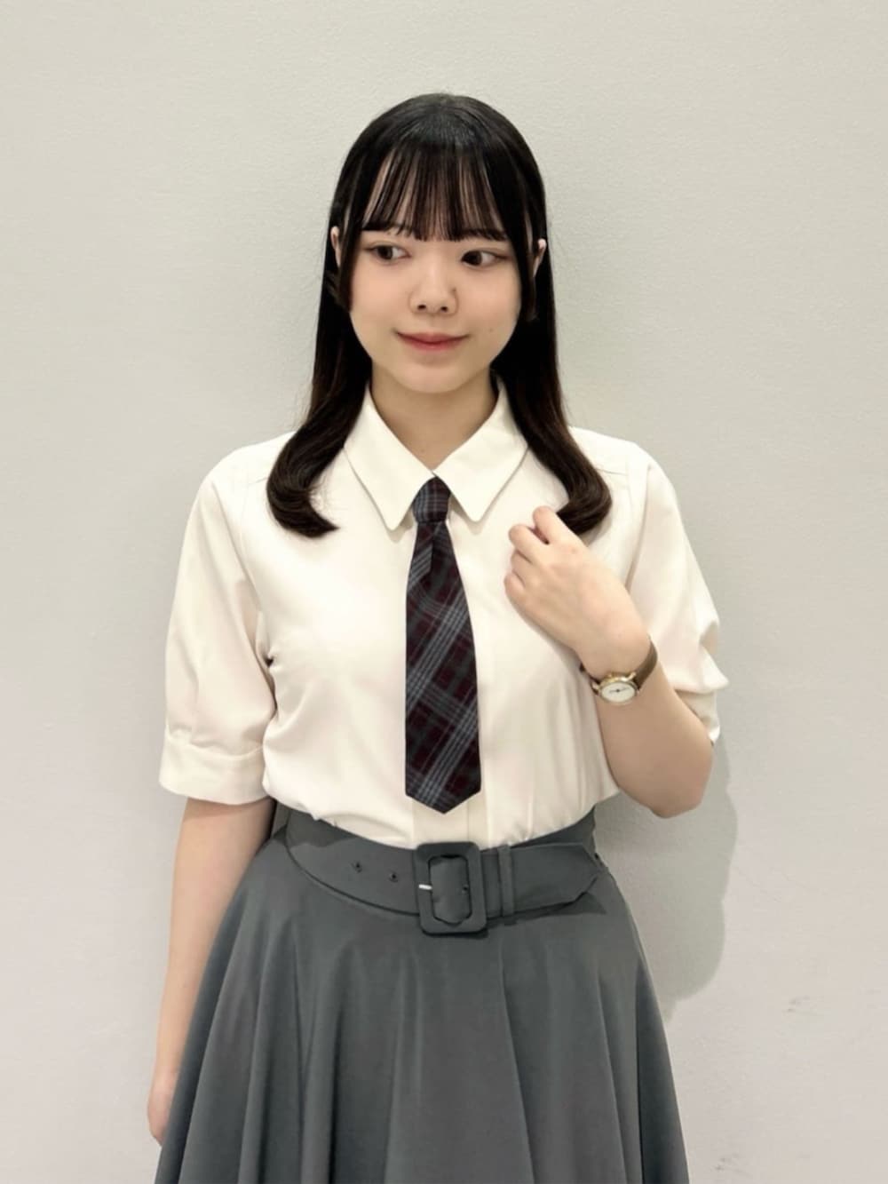 ブラウン系のローファー、グリーン系のスカート、ホワイト系のTシャツ/カットソーを着用したレディースの夏コーディネートの2枚目の写真