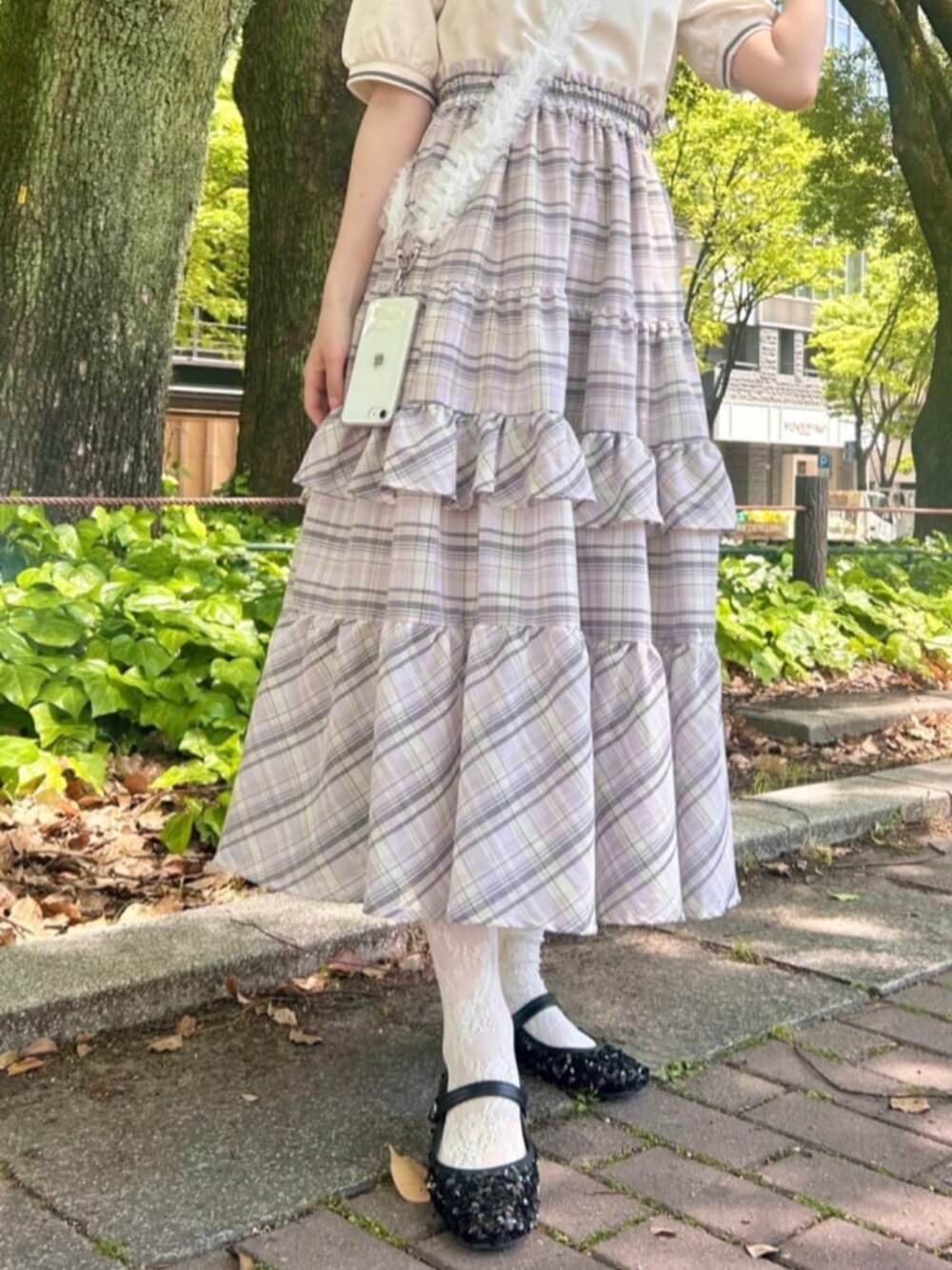 ホワイト系のスカート、ホワイト系のポロシャツを着用したレディースの春コーディネートの3枚目の写真