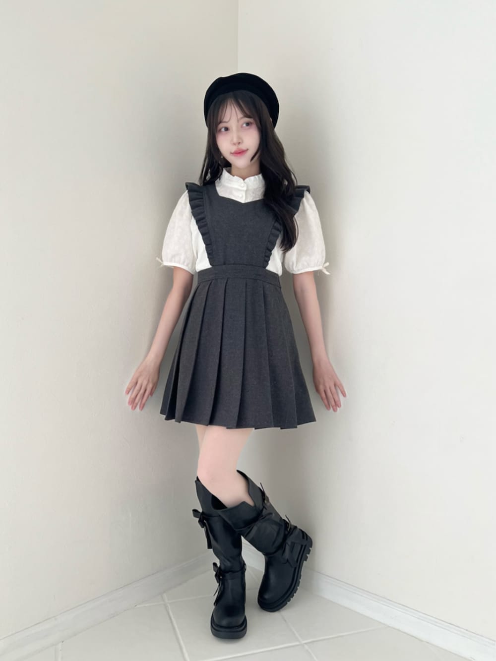 ホワイト系のシャツ/ブラウス、グレー系のジャンパースカート、ブラック系のブーツを着用したレディースの秋コーディネートの3枚目の写真