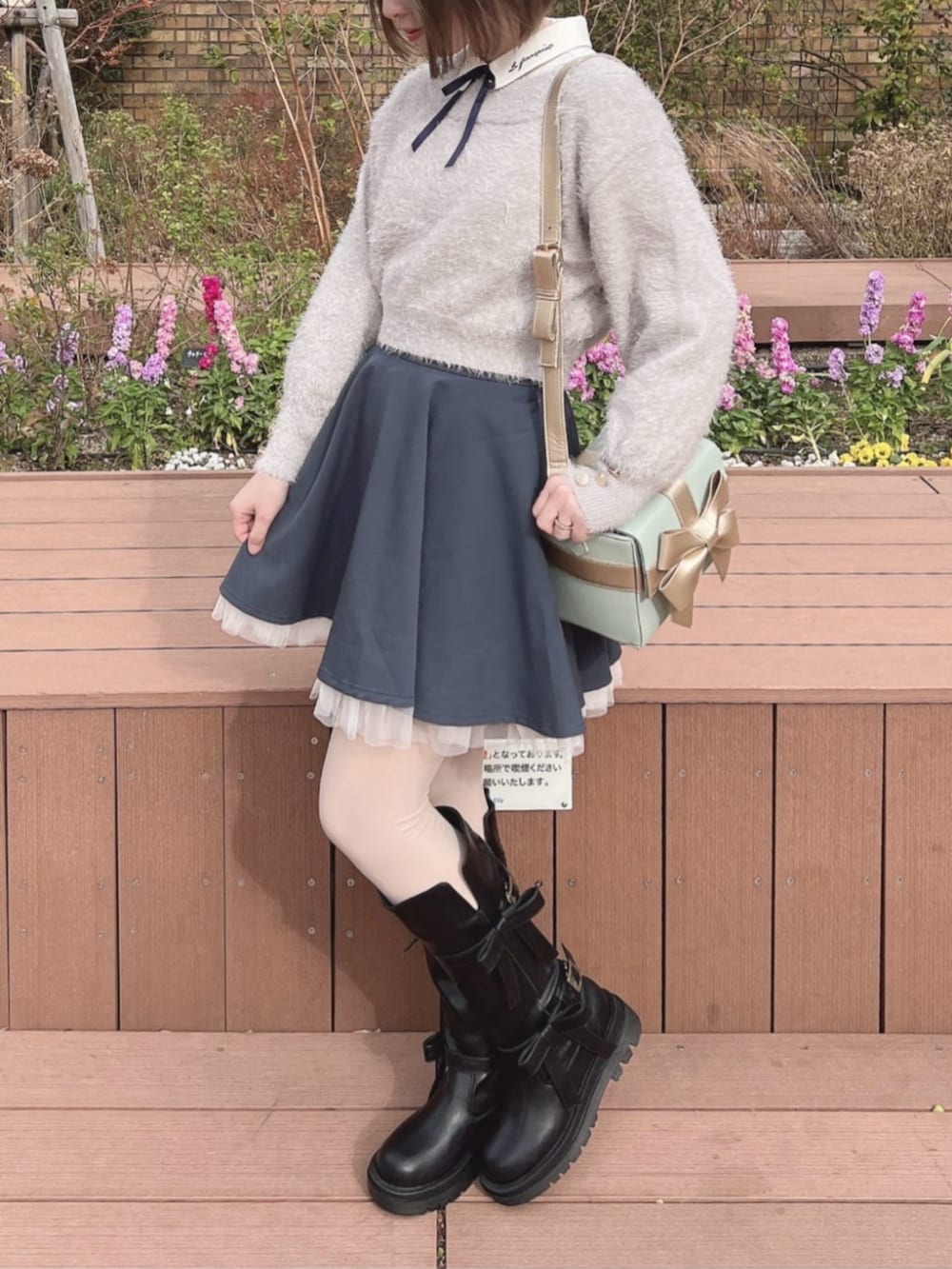 ホワイト系のシャツ/ブラウス、ブラック系のブーツ、グレー系のニット/セーターを着用したレディースの冬コーディネートの2枚目の写真