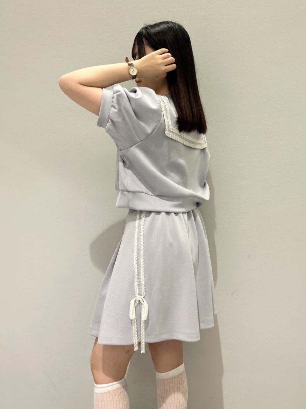 ブルー系のスカート、ホワイト系のハンドバッグ、ホワイト系のサンダルを着用したレディースの夏コーディネートの4枚目の写真