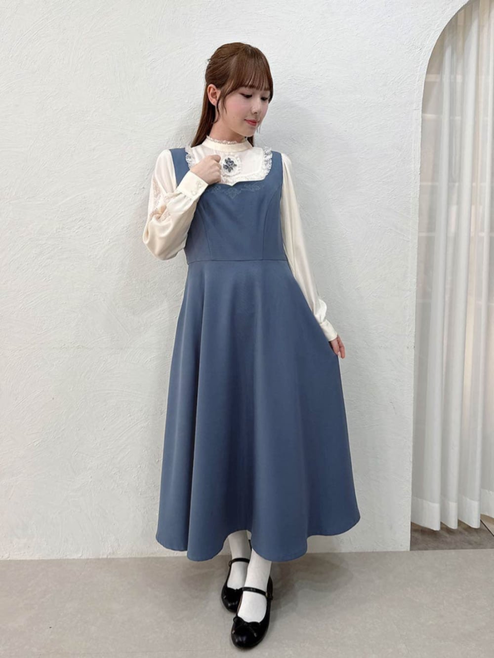 ブラック系のバレエシューズ、ホワイト系のシャツ/ブラウス、ブルー系のジャンパースカートを着用したレディースの秋コーディネートの2枚目の写真