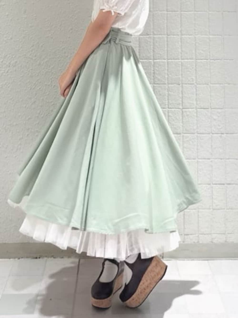 グリーン系のスカート、ホワイト系のシャツ/ブラウス、ブラウン系のパンプスを着用したレディースの夏コーディネートの2枚目の写真