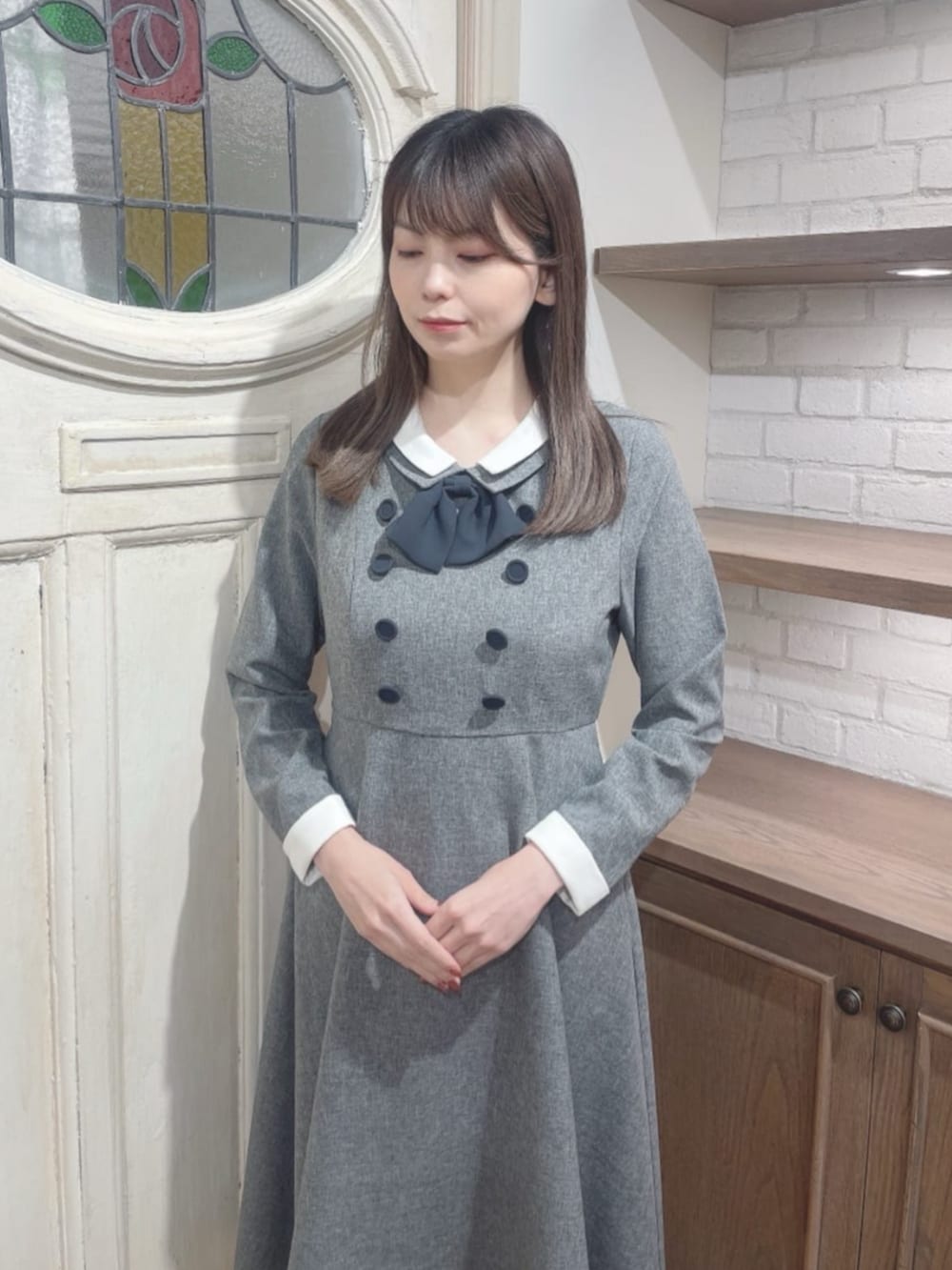 ブラック系のパンプス、グレー系のワンピースを着用したレディースの冬コーディネートの3枚目の写真