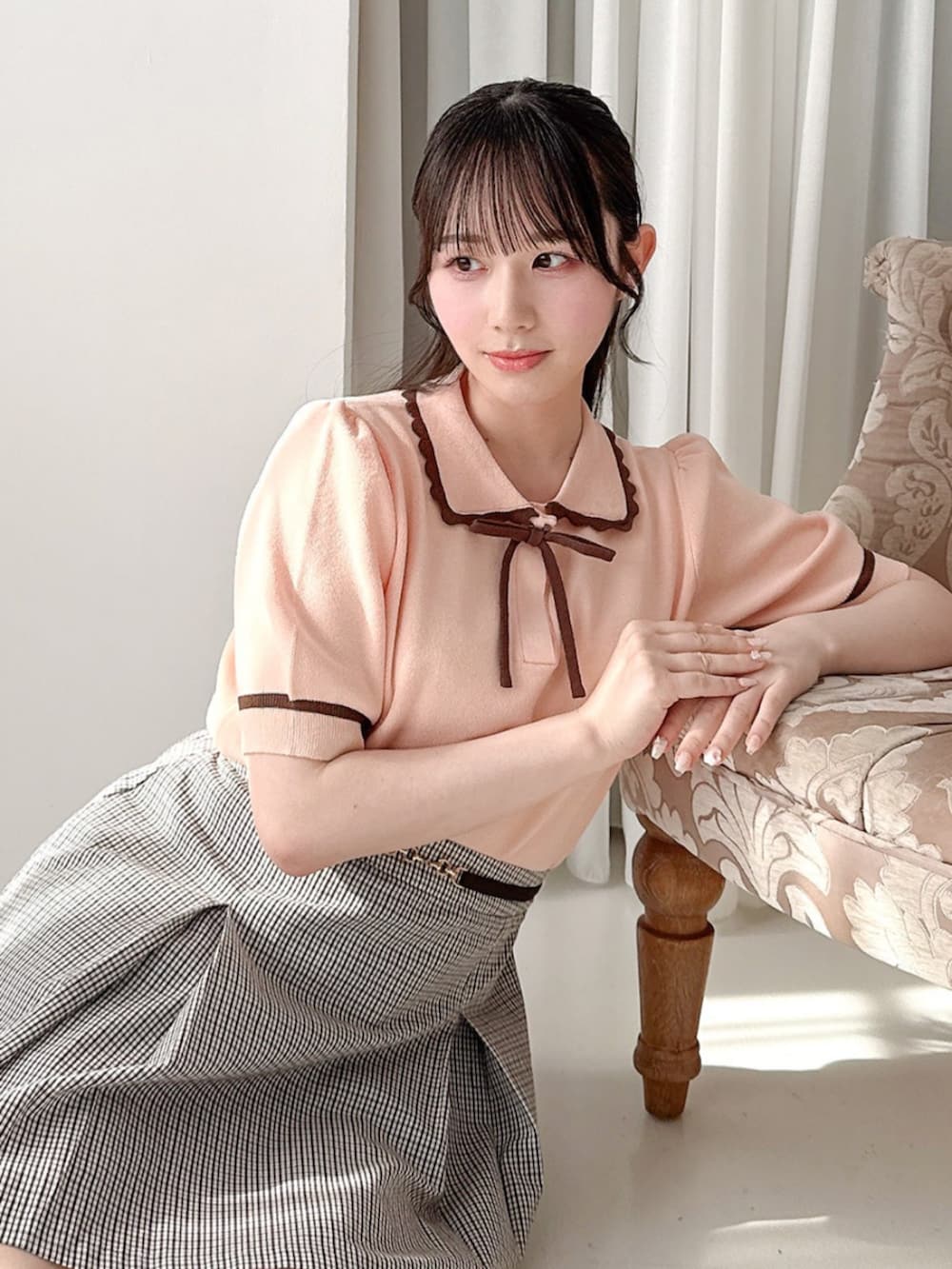 ホワイト系のパンプス、ホワイト系のスカート、ピンク系のポロシャツを着用したレディースの夏コーディネートの2枚目の写真