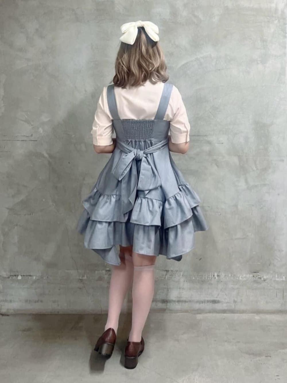 ブラウン系のローファー、ピンク系のシャツ/ブラウス、グレー系のジャンパースカートを着用したレディースの春コーディネートの3枚目の写真