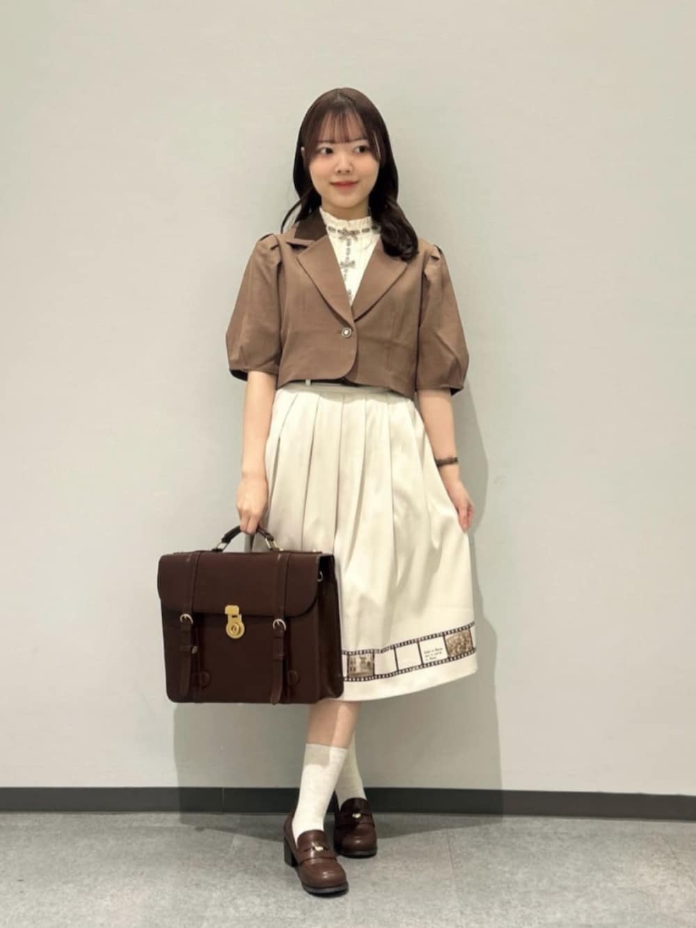 ブラウン系のセットアップ、ブラウン系のローファー、ブラウン系のハンドバッグを着用したレディースの春コーディネートの3枚目の写真