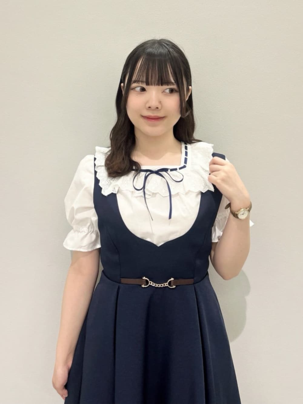 ブラウン系のローファー、ブルー系のジャンパースカート、ホワイト系のシャツ/ブラウスを着用したレディースの夏コーディネートの3枚目の写真