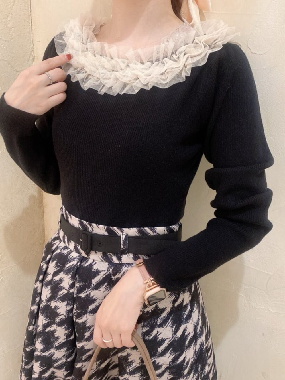 ブラック系のパンプス、ベージュ系のスカート、ブラック系のニット/セーターを着用したレディースの秋コーディネートの2枚目の写真