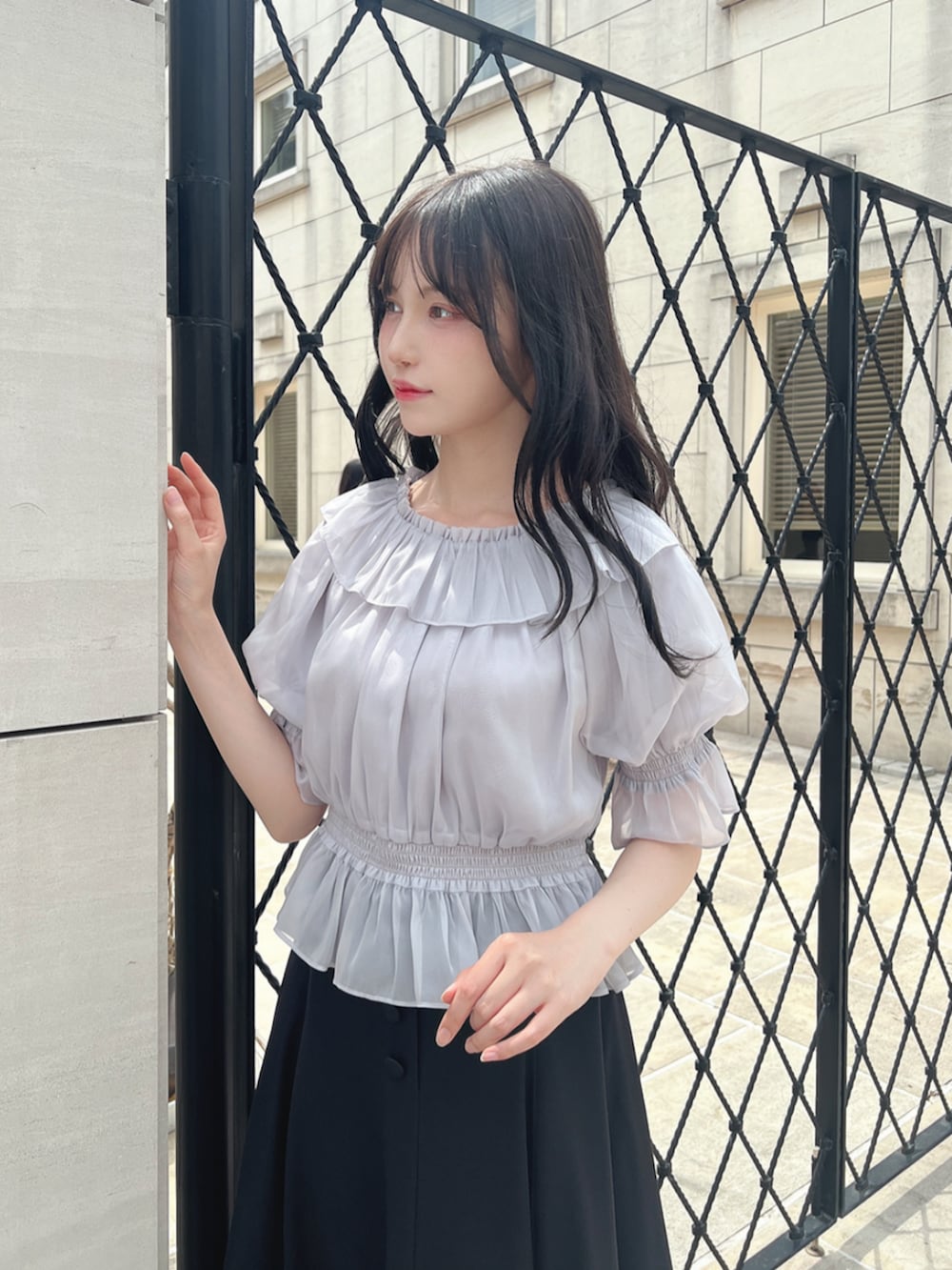 ブラック系のスカート、ブラック系のパンプス、グレー系のシャツ/ブラウスを着用したレディースの夏コーディネートの2枚目の写真