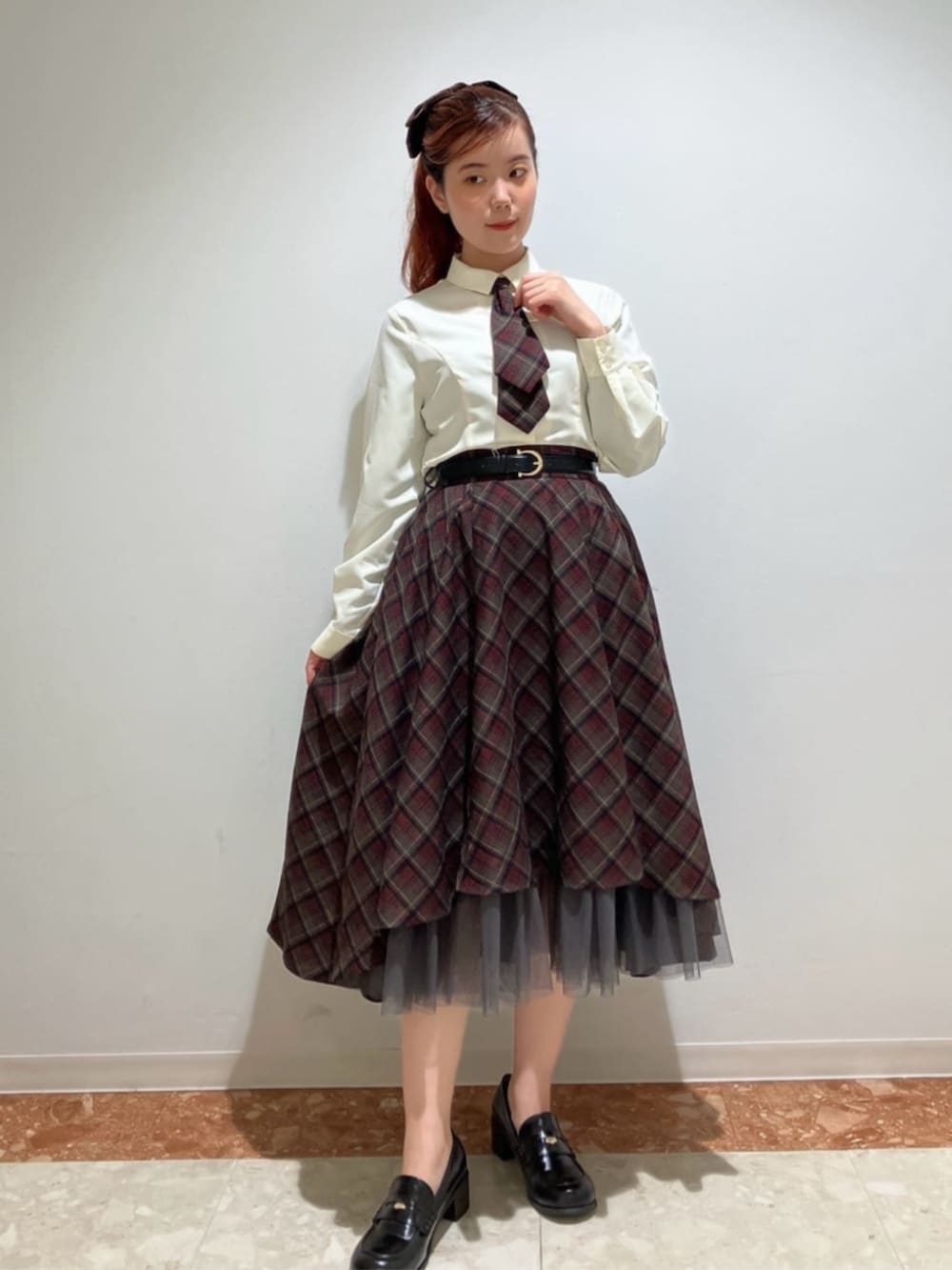 ブラック系のローファー、ブラック系のスカート、ホワイト系のシャツ/ブラウスを着用したレディースの冬コーディネートの3枚目の写真