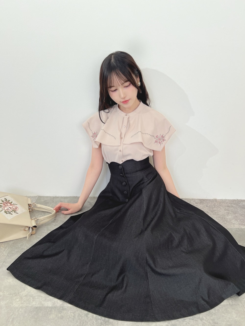 ブラック系のパンプス、ピンク系のシャツ/ブラウス、ブラック系のデニムスカートを着用したレディースの夏コーディネートの2枚目の写真