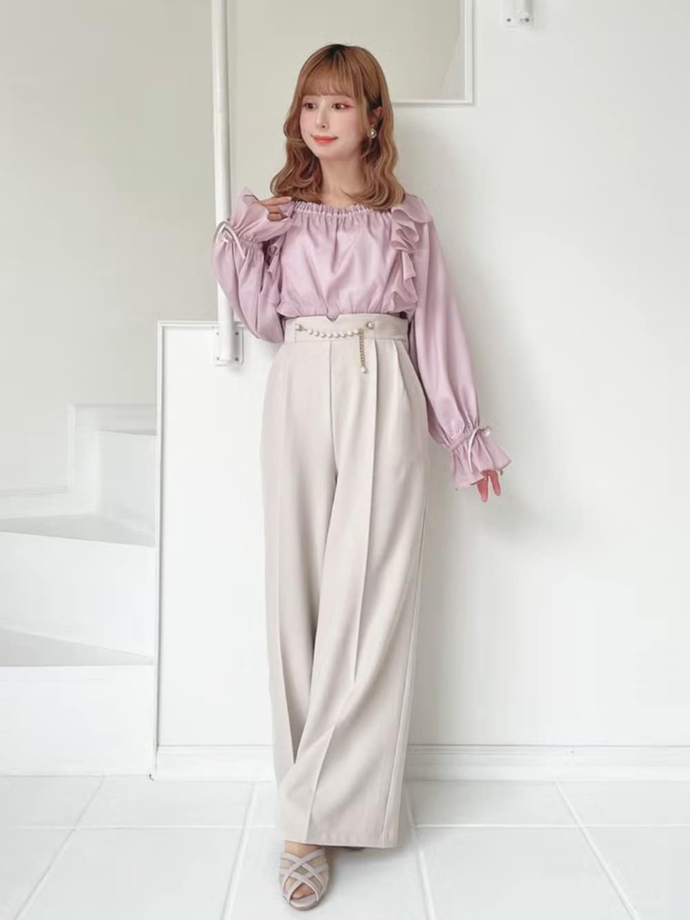 ピンク系のシャツ/ブラウス、ベージュ系のパンツを着用したレディースの春コーディネートの2枚目の写真