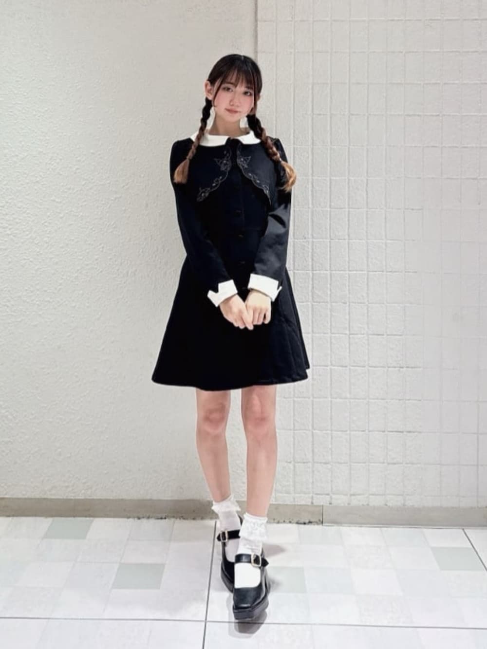 ブラック系のパンプス、ブラック系のワンピース、ホワイト系のハンチング/ベレー帽を着用したレディースの冬コーディネートの3枚目の写真