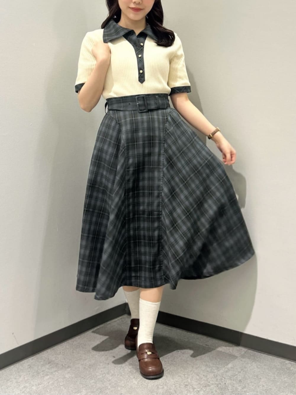 ブラウン系のローファー、ブラウン系のハンドバッグ、グリーン系のスカートを着用したレディースの春コーディネートの4枚目の写真