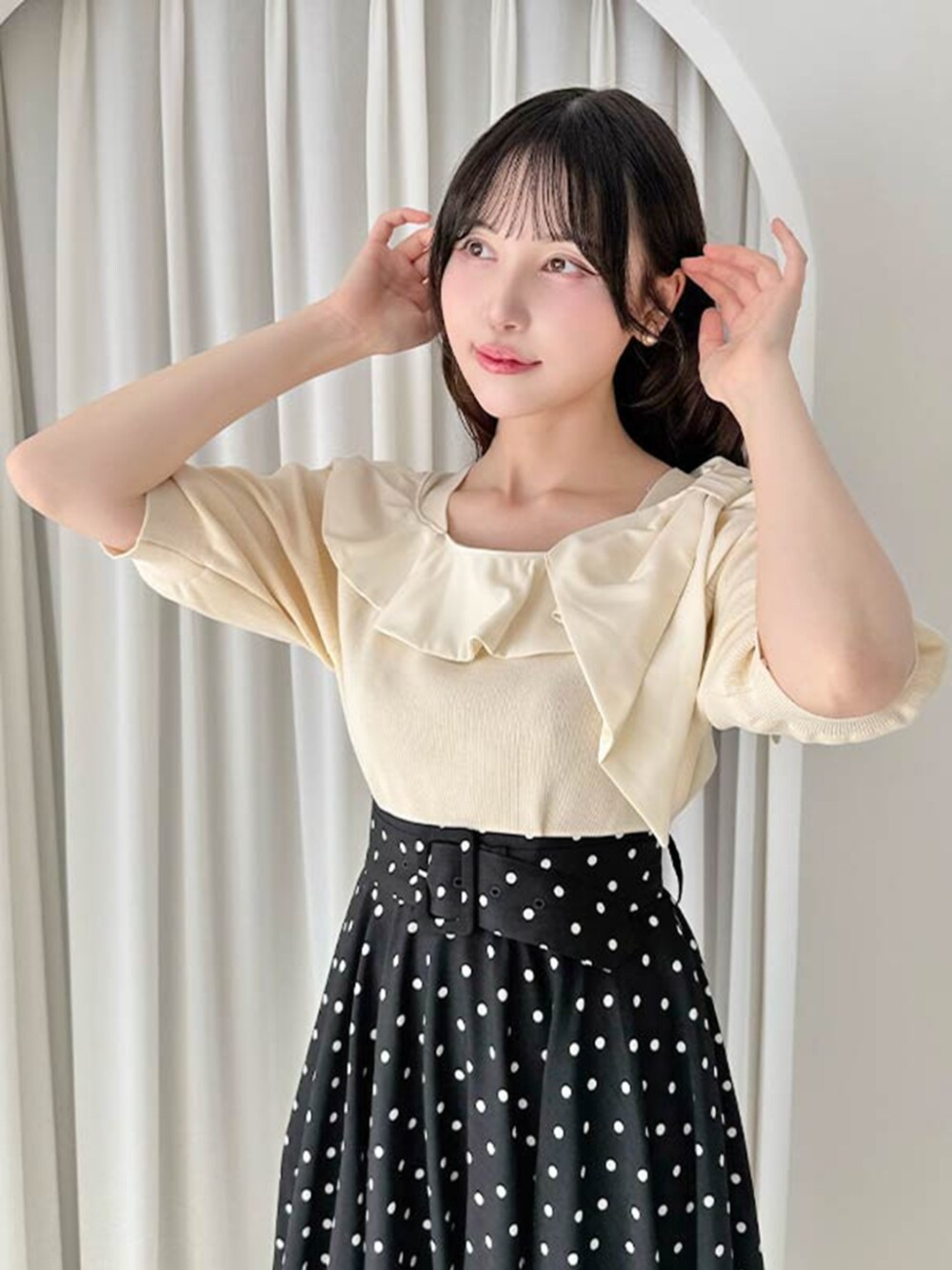 ホワイト系のパンプス、ブラック系のスカート、ホワイト系のニット/セーターを着用したレディースの夏コーディネートの3枚目の写真