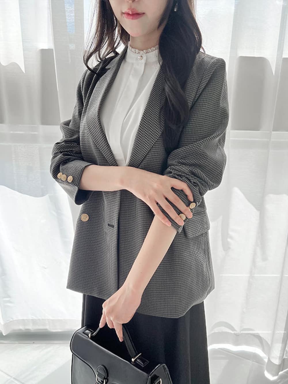 ブラック系のハンドバッグ、ブラック系のデニムスカート、ホワイト系のシャツ/ブラウスを着用したレディースの秋コーディネートの4枚目の写真