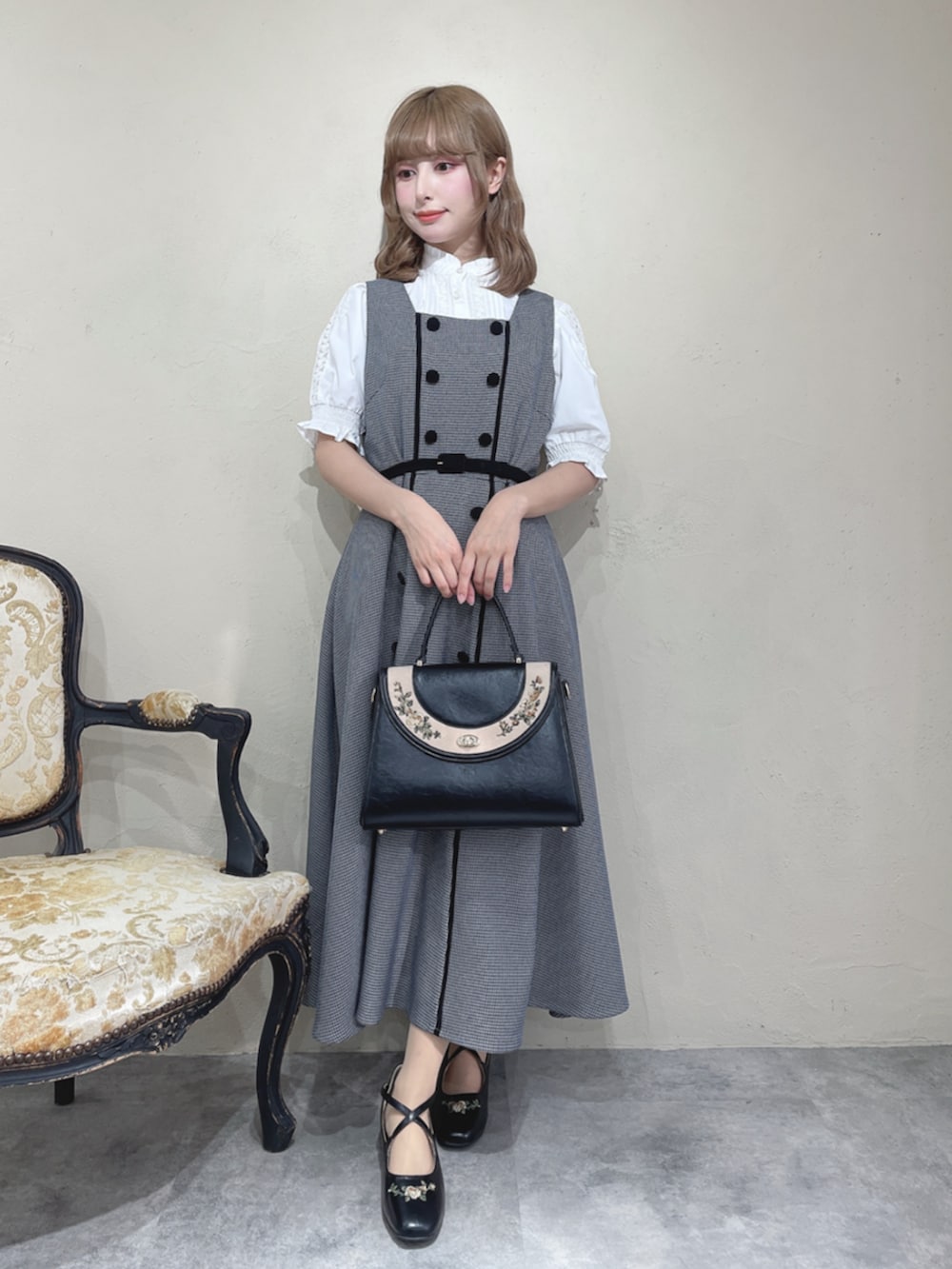 ホワイト系のシャツ/ブラウス、ブラック系のセットアップ、ブラック系のハンドバッグを着用したレディースの秋コーディネートの3枚目の写真