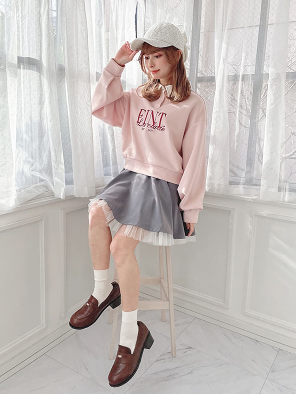 グレー系のスカート、ブラウン系のローファー、ピンク系のスウェットを着用したレディースの冬コーディネートの3枚目の写真