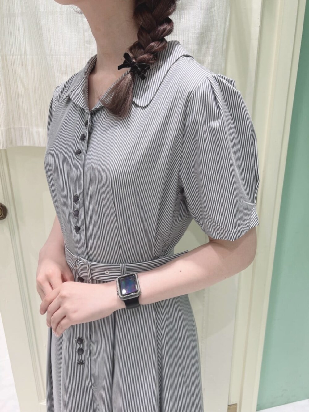 ホワイト系のパンプス、ホワイト系のシャツワンピース、ブルー系のカーディガン/ボレロを着用したレディースの夏コーディネートの3枚目の写真