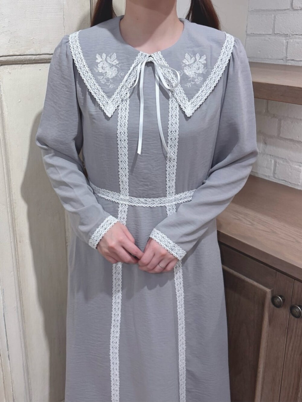 グレー系のワンピース、ブラウン系のパンプスを着用したレディースの秋コーディネートの3枚目の写真