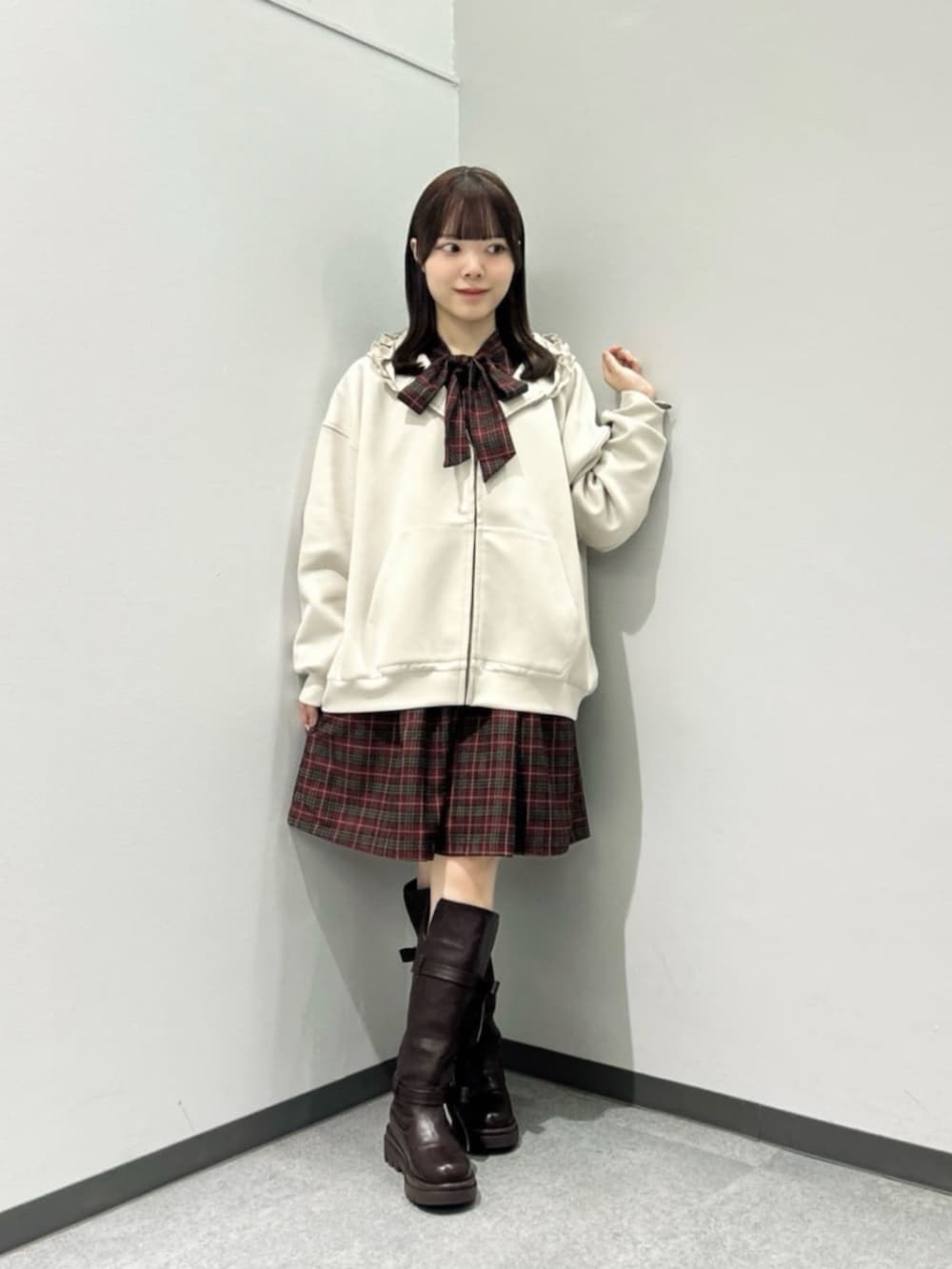 ブラウン系のブーツ、レッド系のワンピース、ベージュ系のパーカーを着用したレディースの秋コーディネートの2枚目の写真