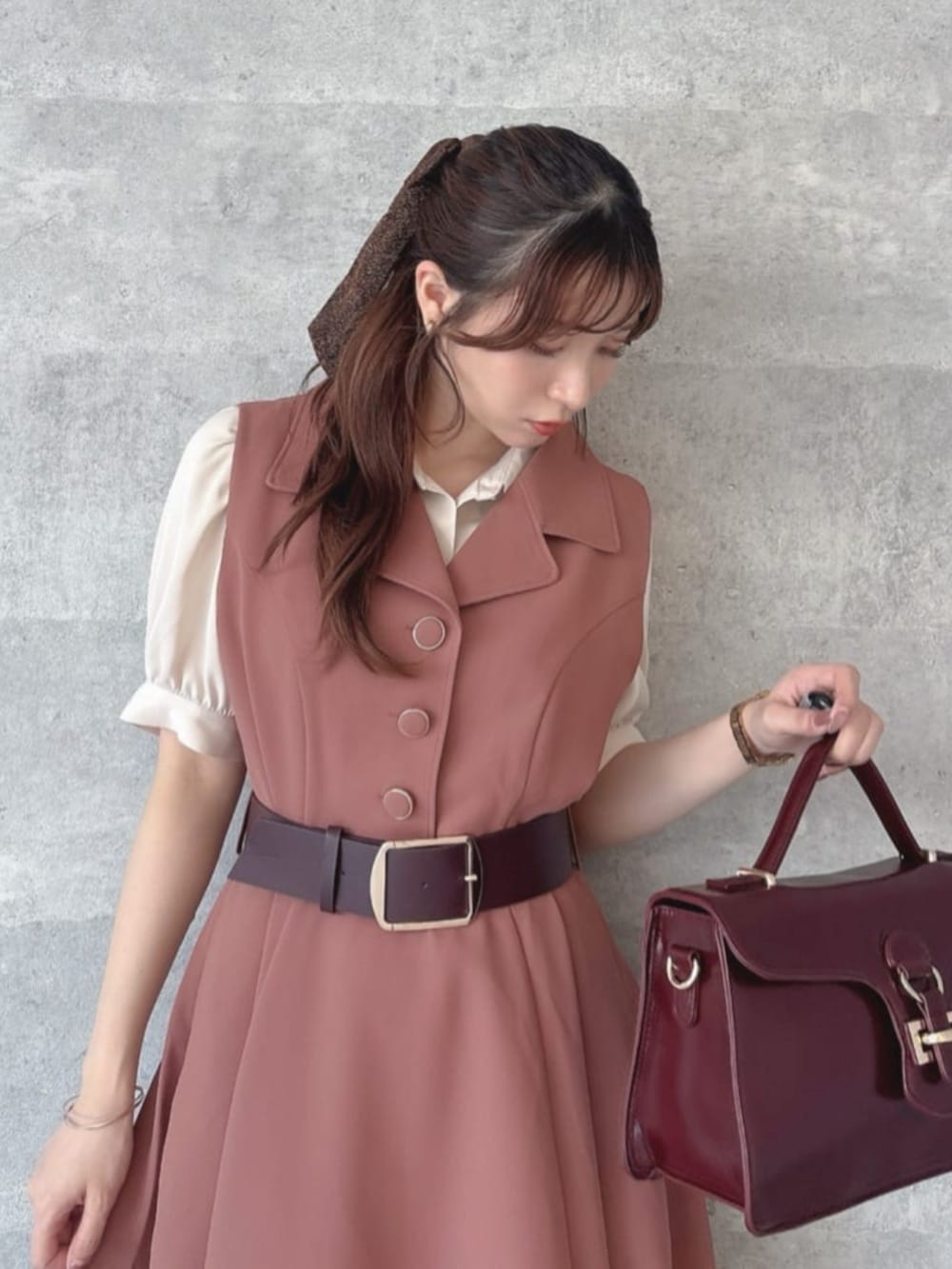 レッド系のハンドバッグ、レッド系のワンピース、ベージュ系のシャツ/ブラウスを着用したレディースの夏コーディネートの2枚目の写真