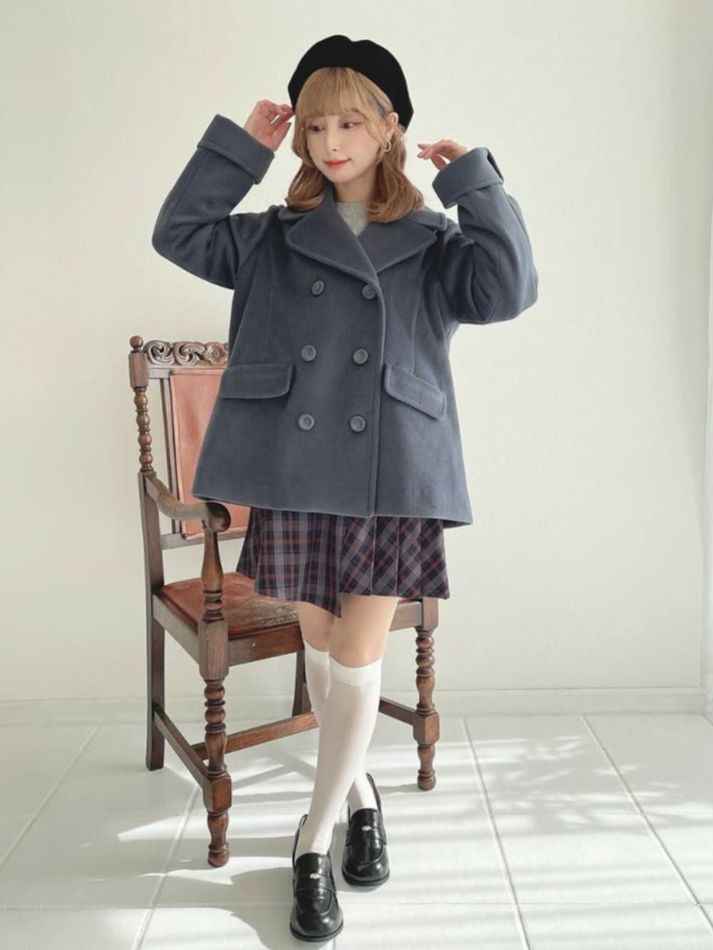 ブラック系のローファー、ブルー系のスカート、グレー系のピーコートを着用したレディースの秋コーディネートの2枚目の写真
