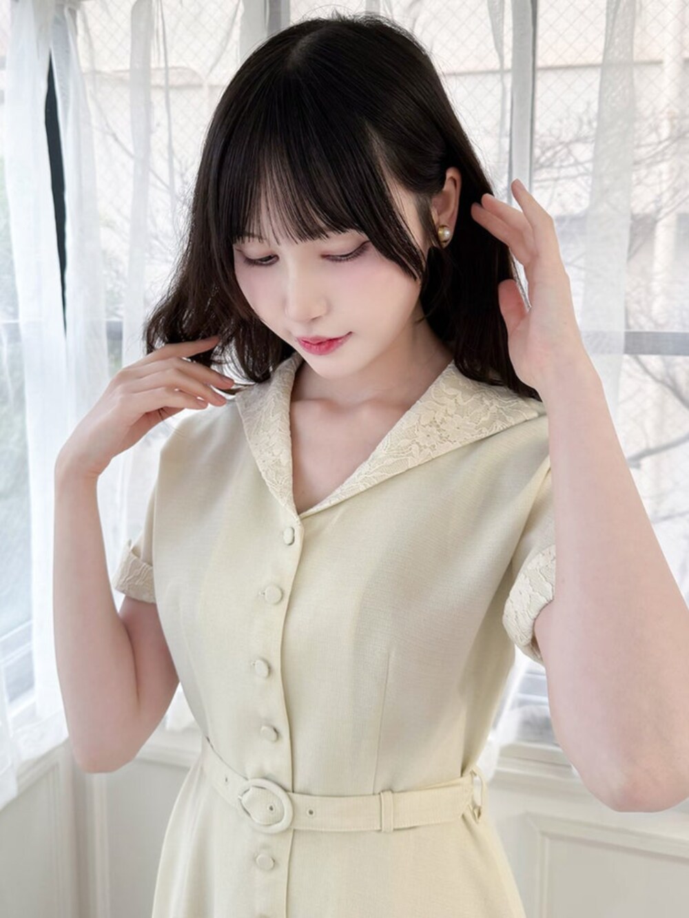 ブルー系のハンドバッグ、ホワイト系のパンプス、ベージュ系のワンピースを着用したレディースの春コーディネートの2枚目の写真